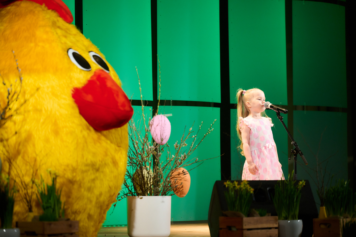 Konkursa dalībnieks dzied uz skatuves mikrofonā