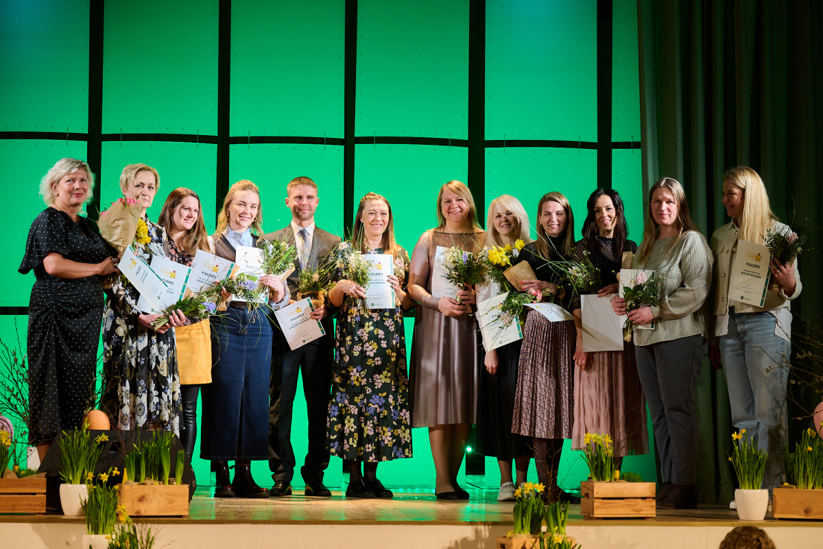 Konkursa vokālie pedagogi uz skatuves ar ziediem rokās