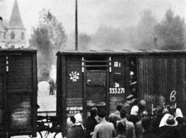 Sena kartiņa ar vilciena vagonu un cilvēkiem, kas glabā liecību par masu deportācijām