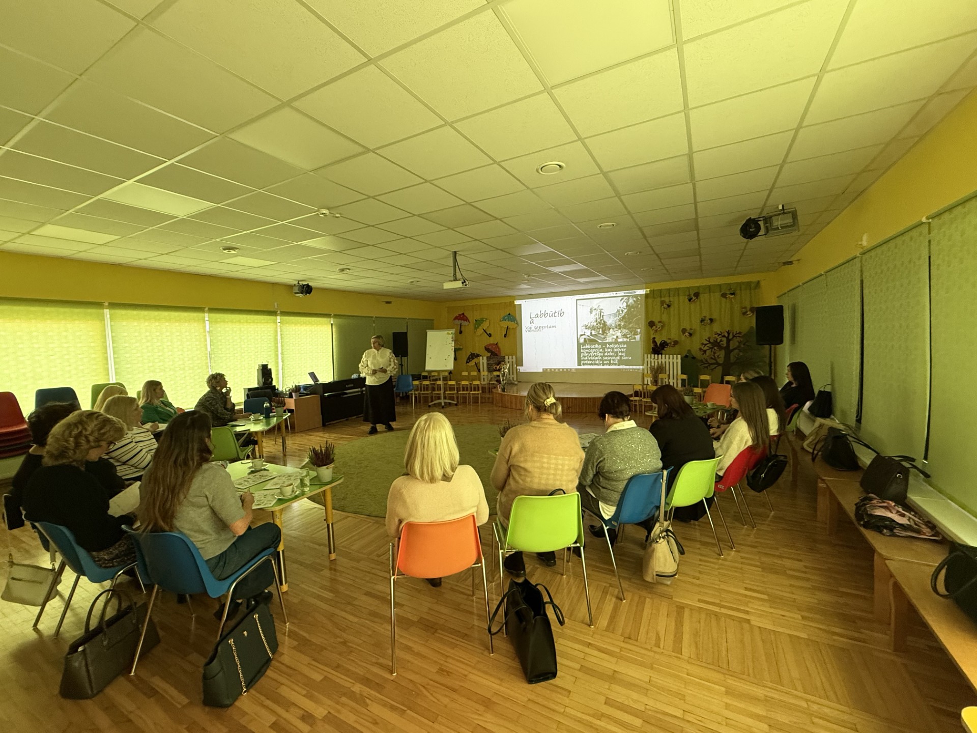 Daudz cilvēki sēž un skatās ekrānā