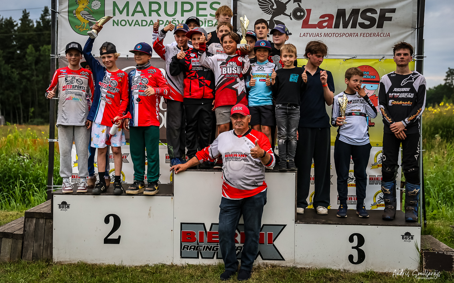 Daudz bērni un jauniešu sporta tērpos uz pjedestāla