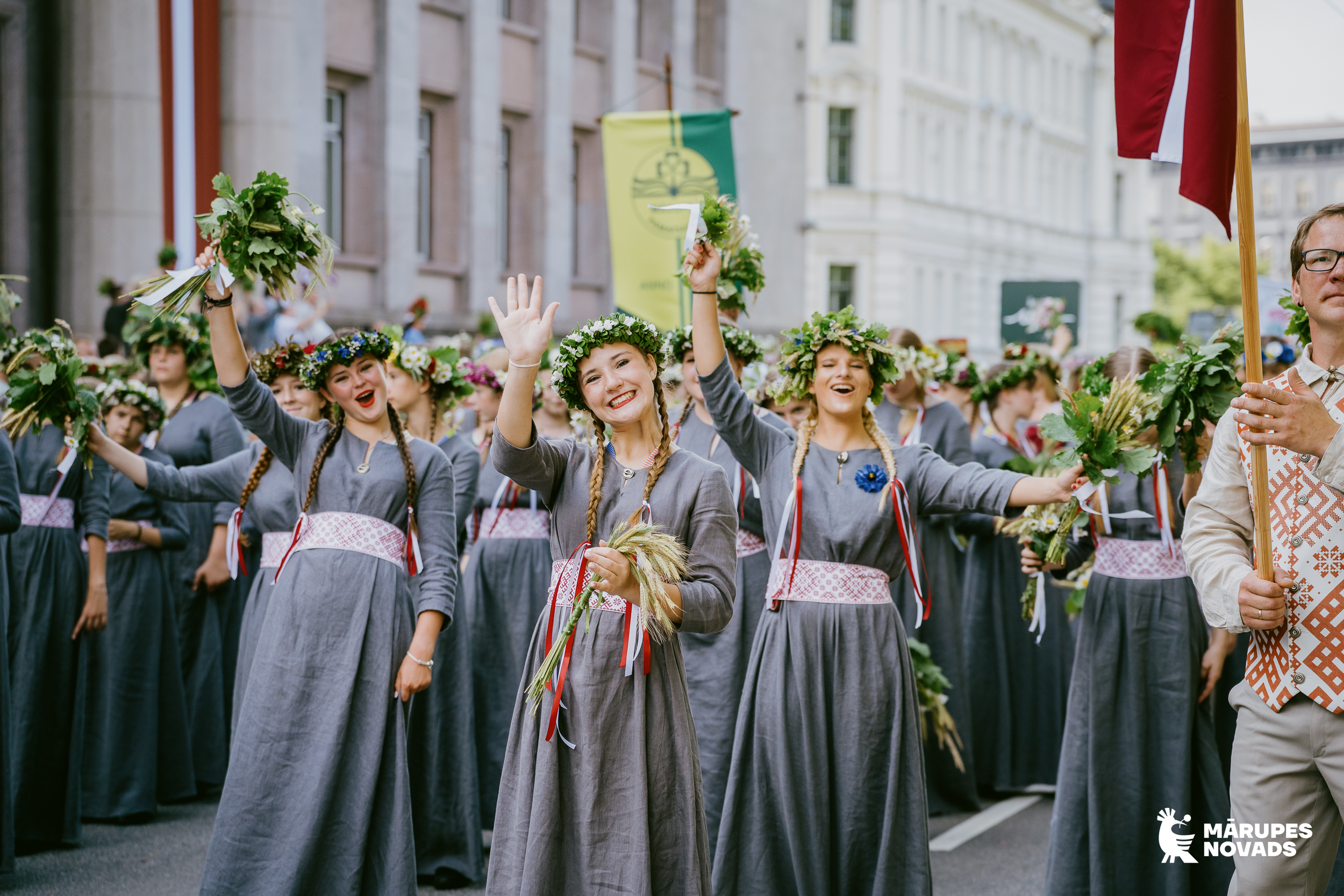 Meitenes pelēkās kleitās ar vainagiem galvā