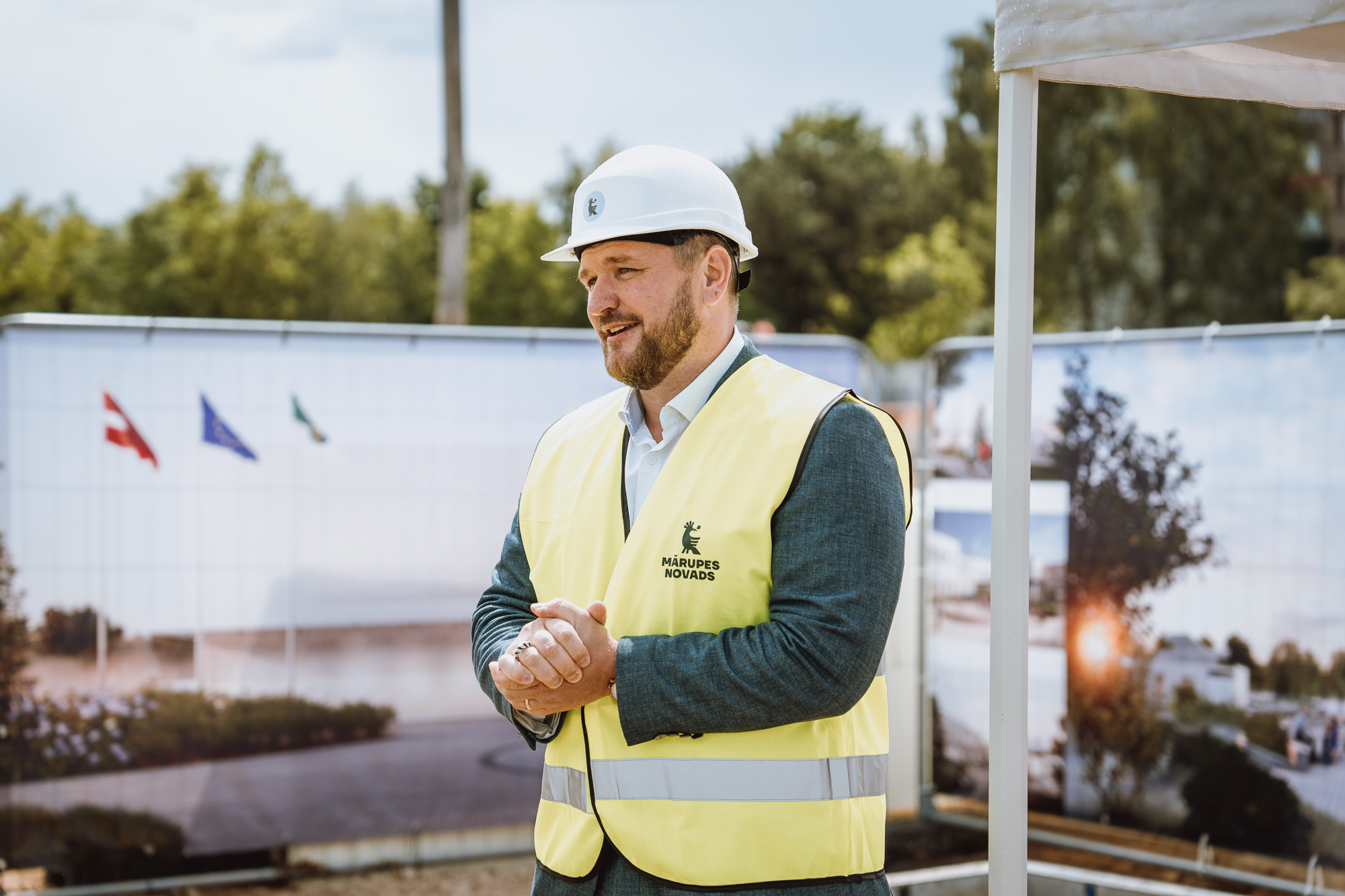 Vīrietis ar baltu ķiveri un dzeltenu vesti