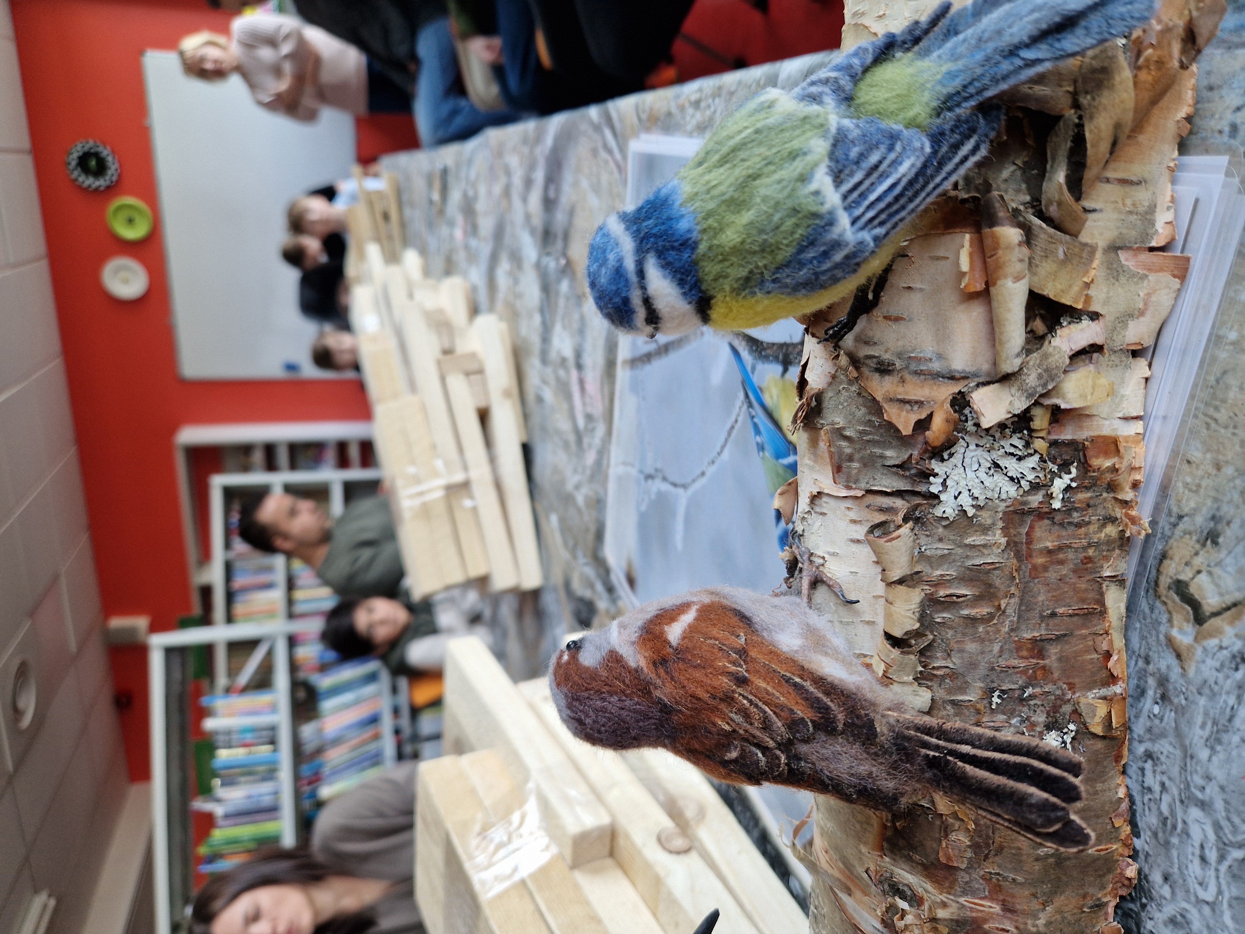 cilvēku grupa brīvdabā veido putnu būrus