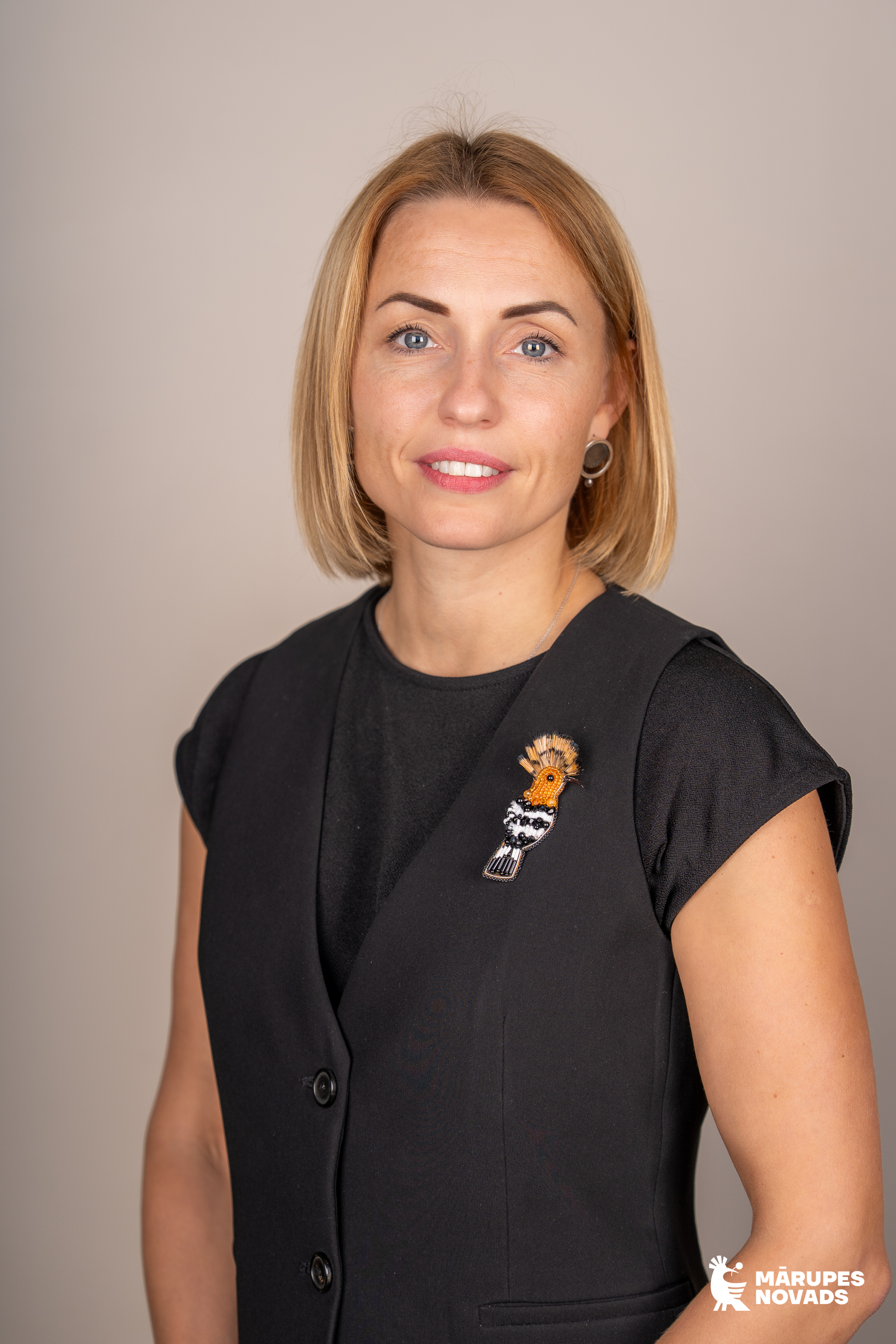 Sievietes profils tumšās drēbēs uz gaiša fona