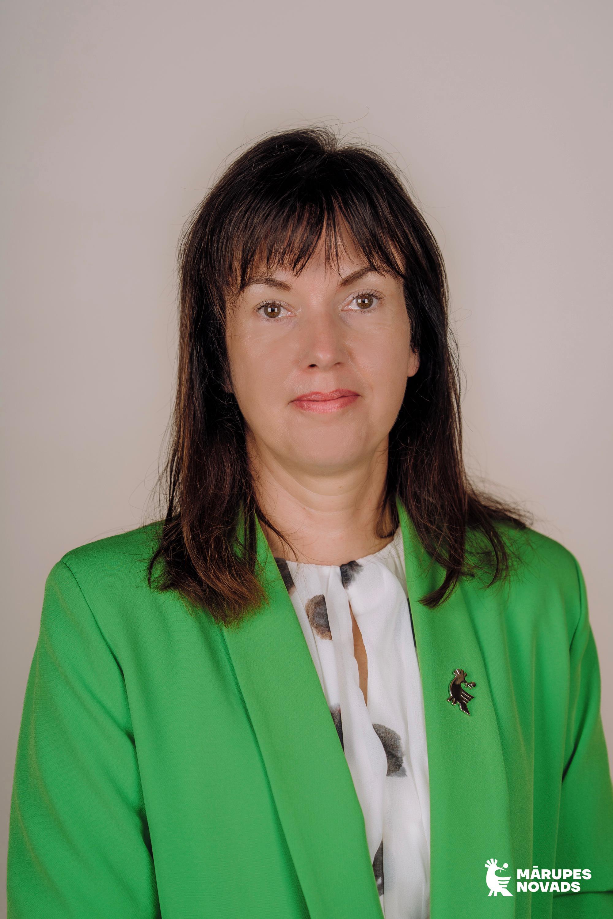 Sieviete krāsainās drēbēs uz gaiša fona