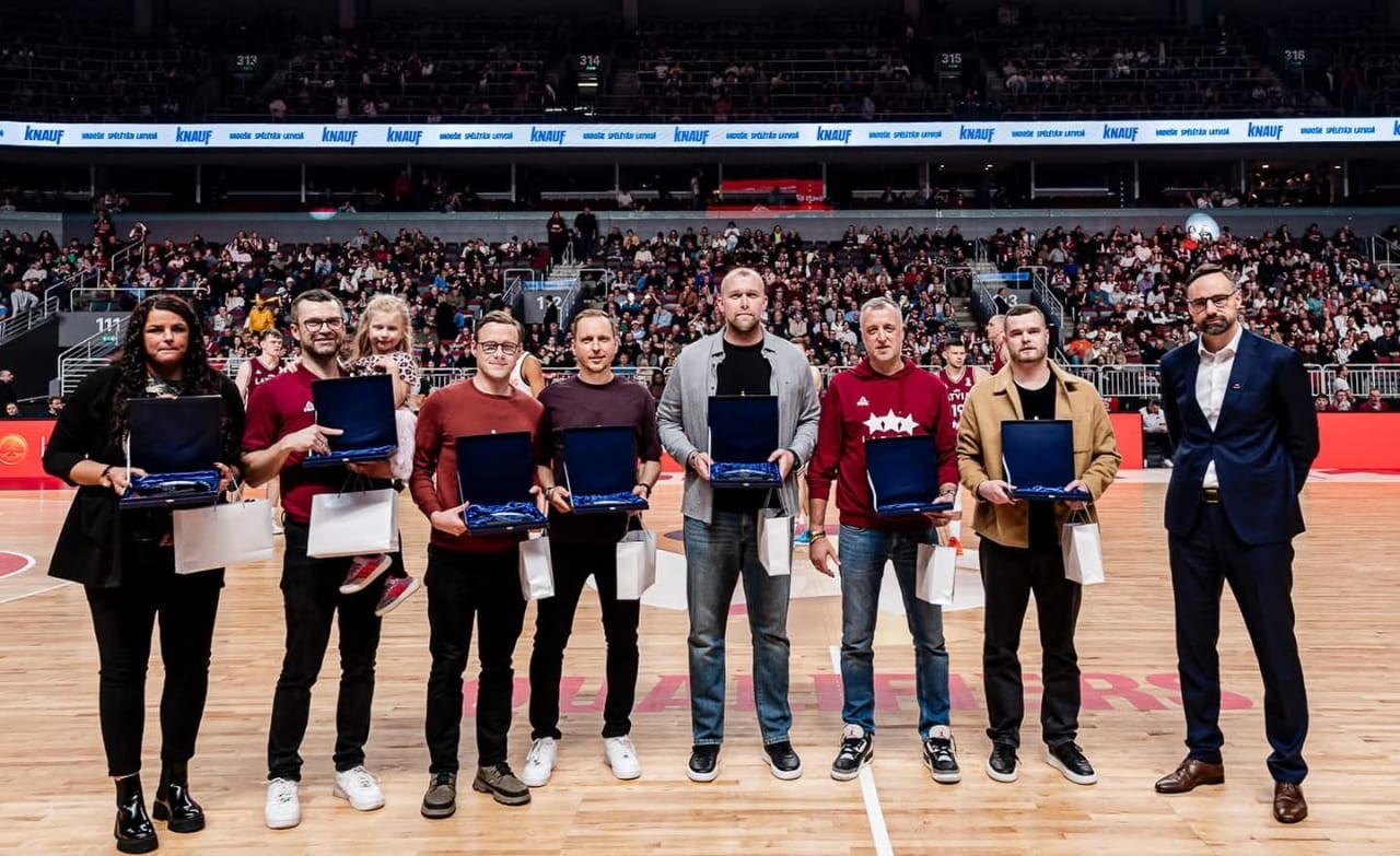 Vairāki cilvēki stāv basketbola laukumā