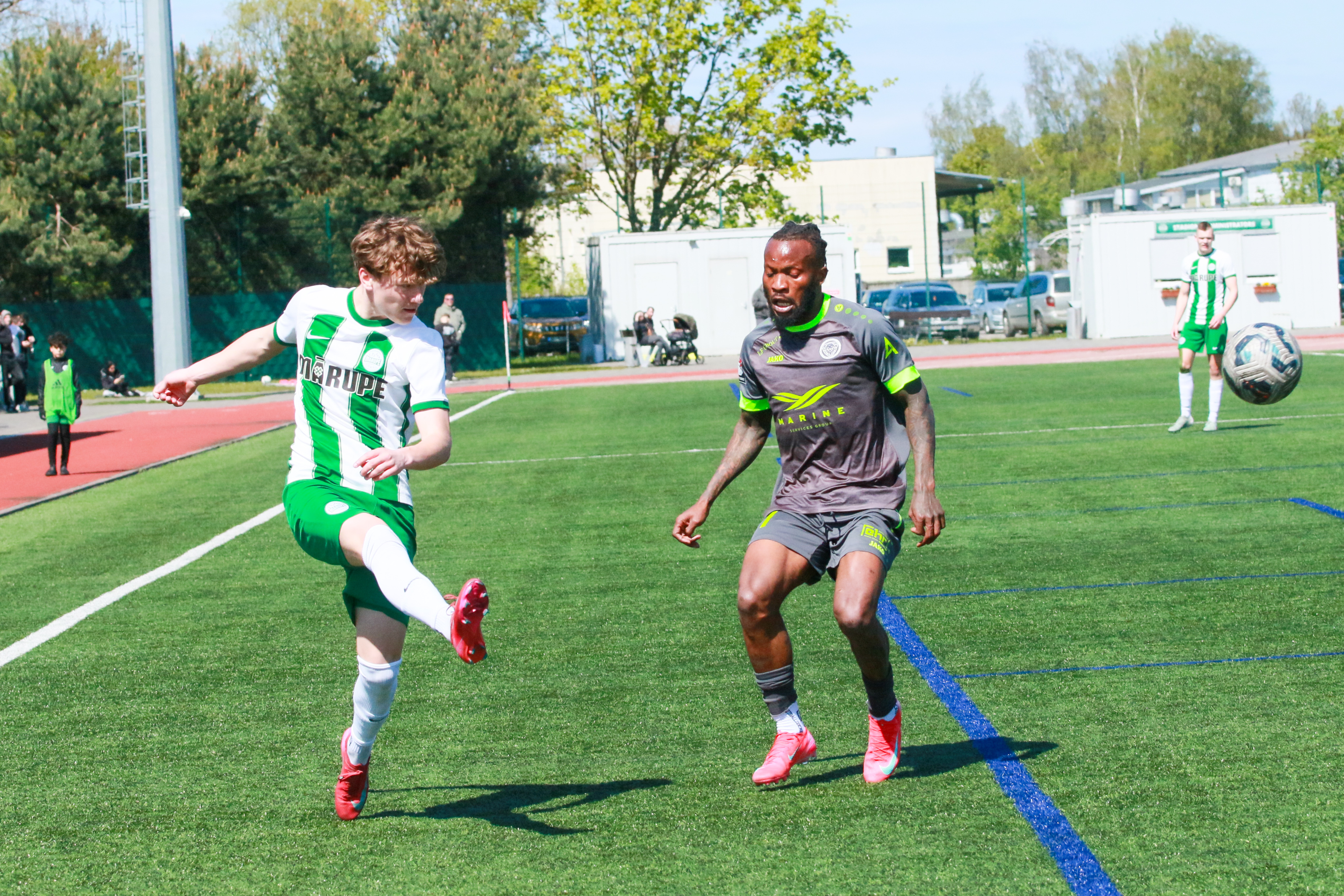 Divi futbolisti uz zaļa zāliena