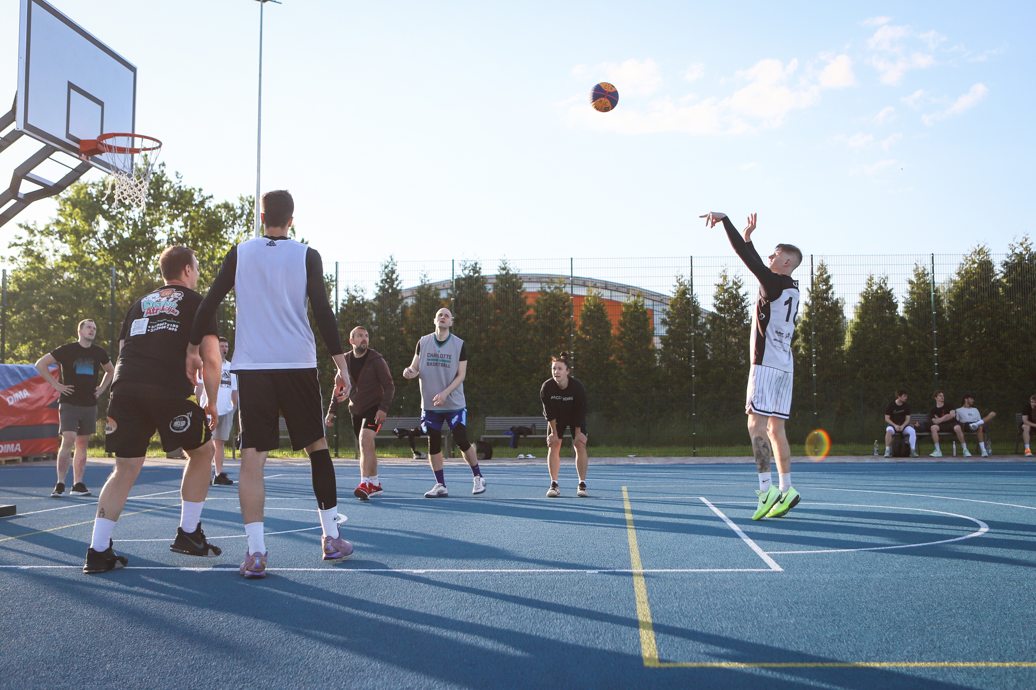 puiši spēlē basketbola uz zila seguma sporta laukumā