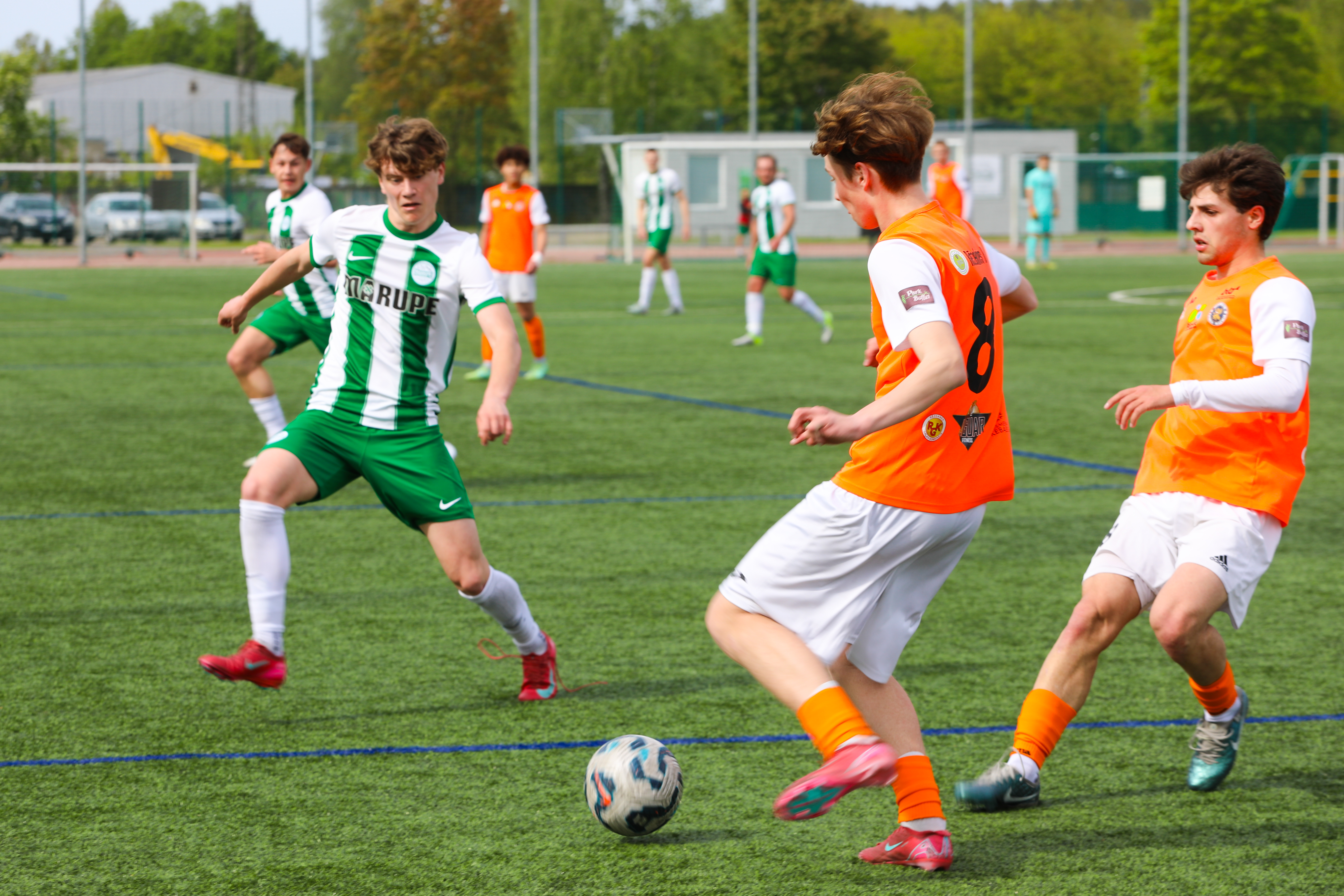 Futbola spēlētāji uz zaļa zāliena