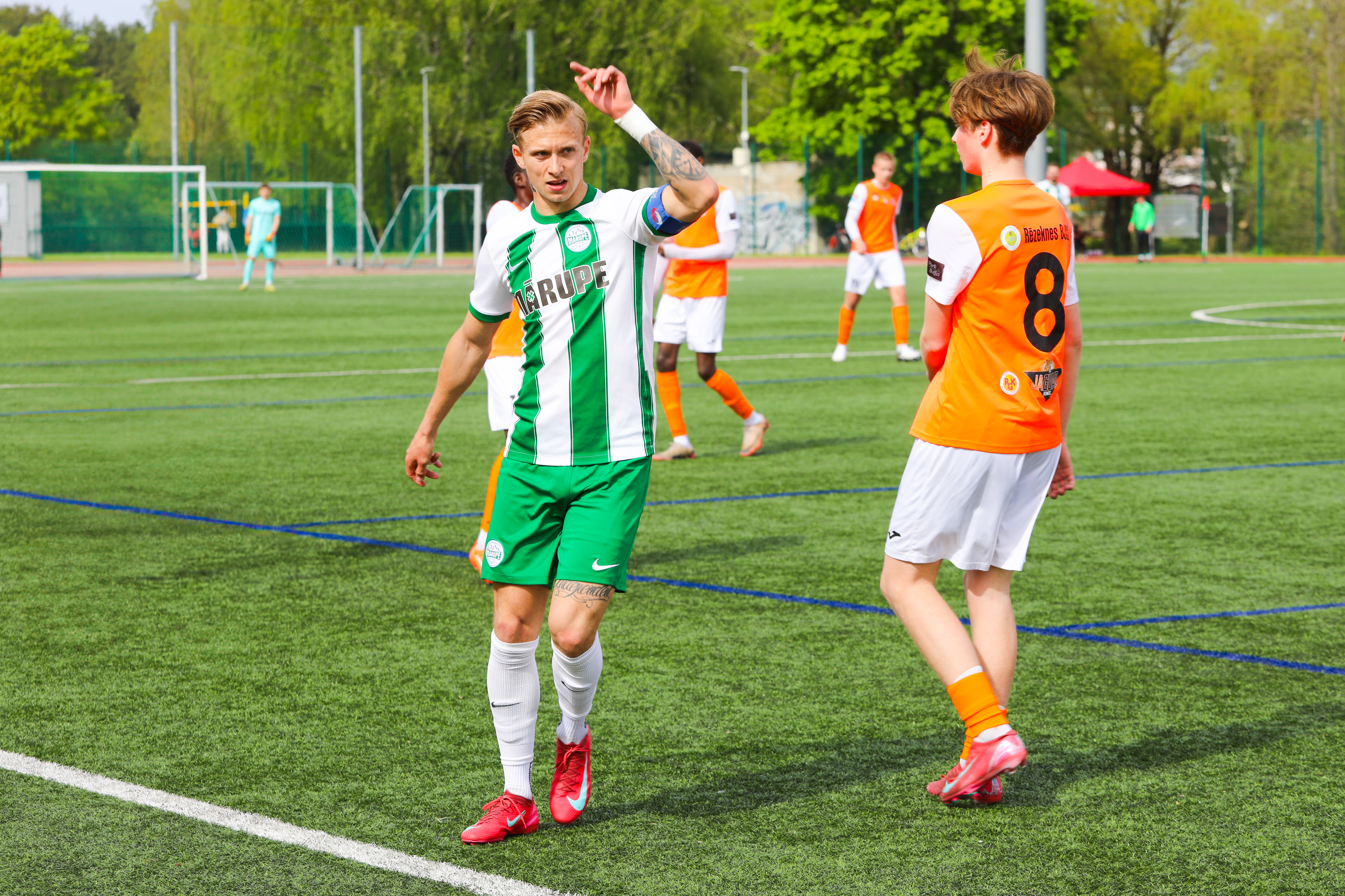 Futbola spēlētāji uz zaļa zāliena