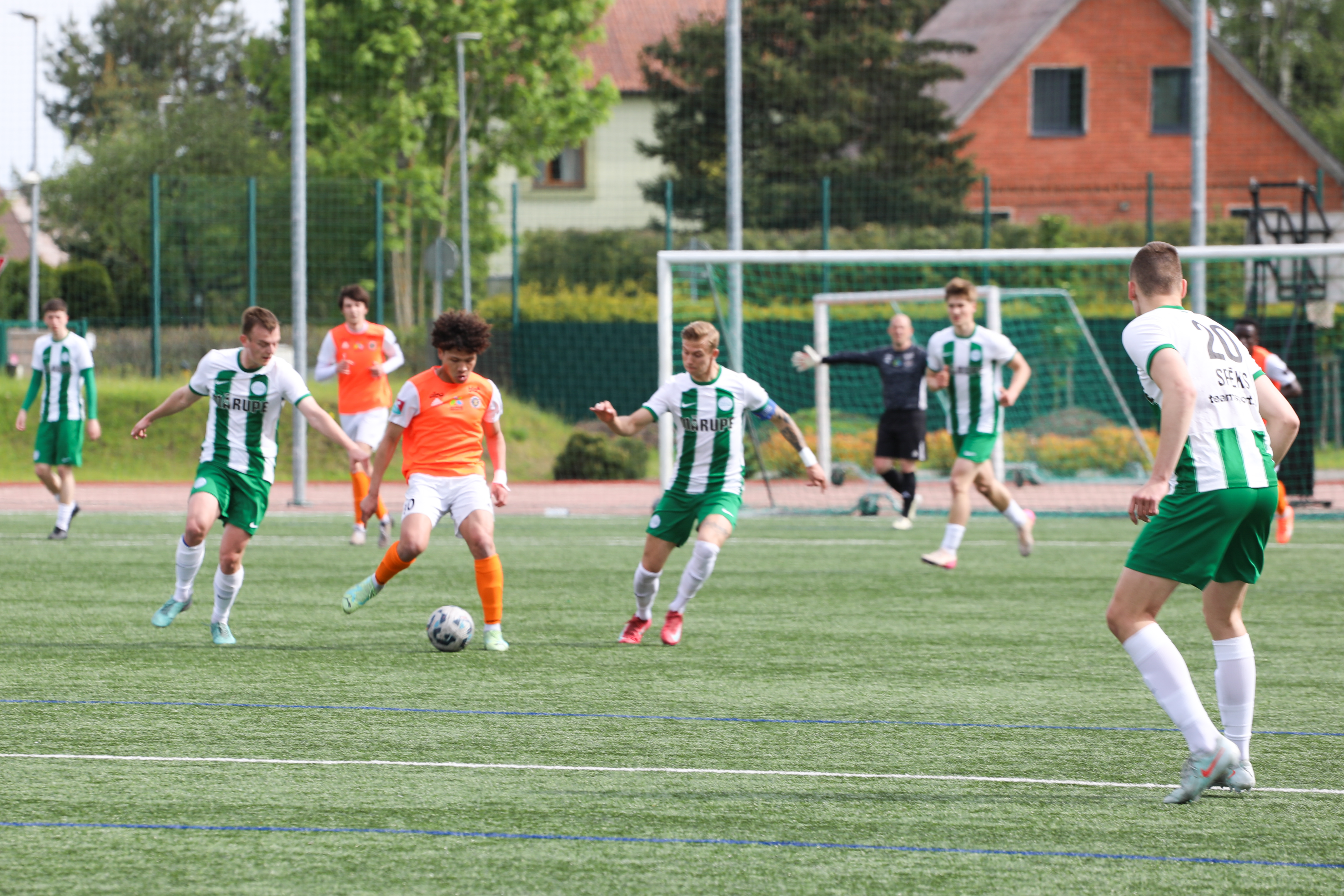 Futbola spēlētāji uz zaļa zāliena