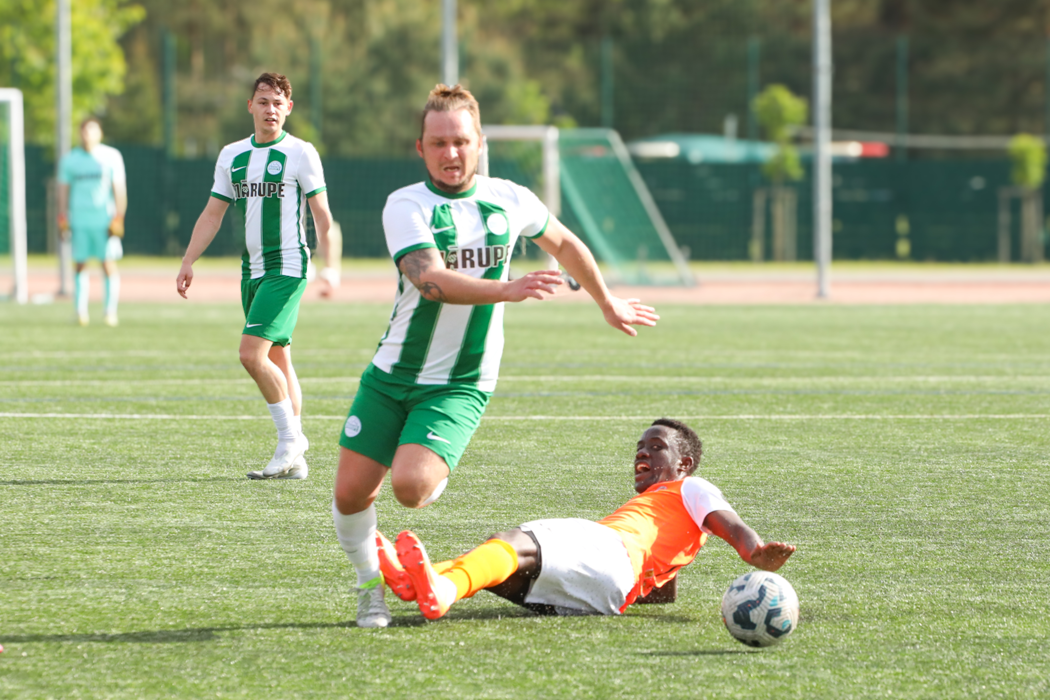 Futbola spēlētāji uz zaļa zāliena