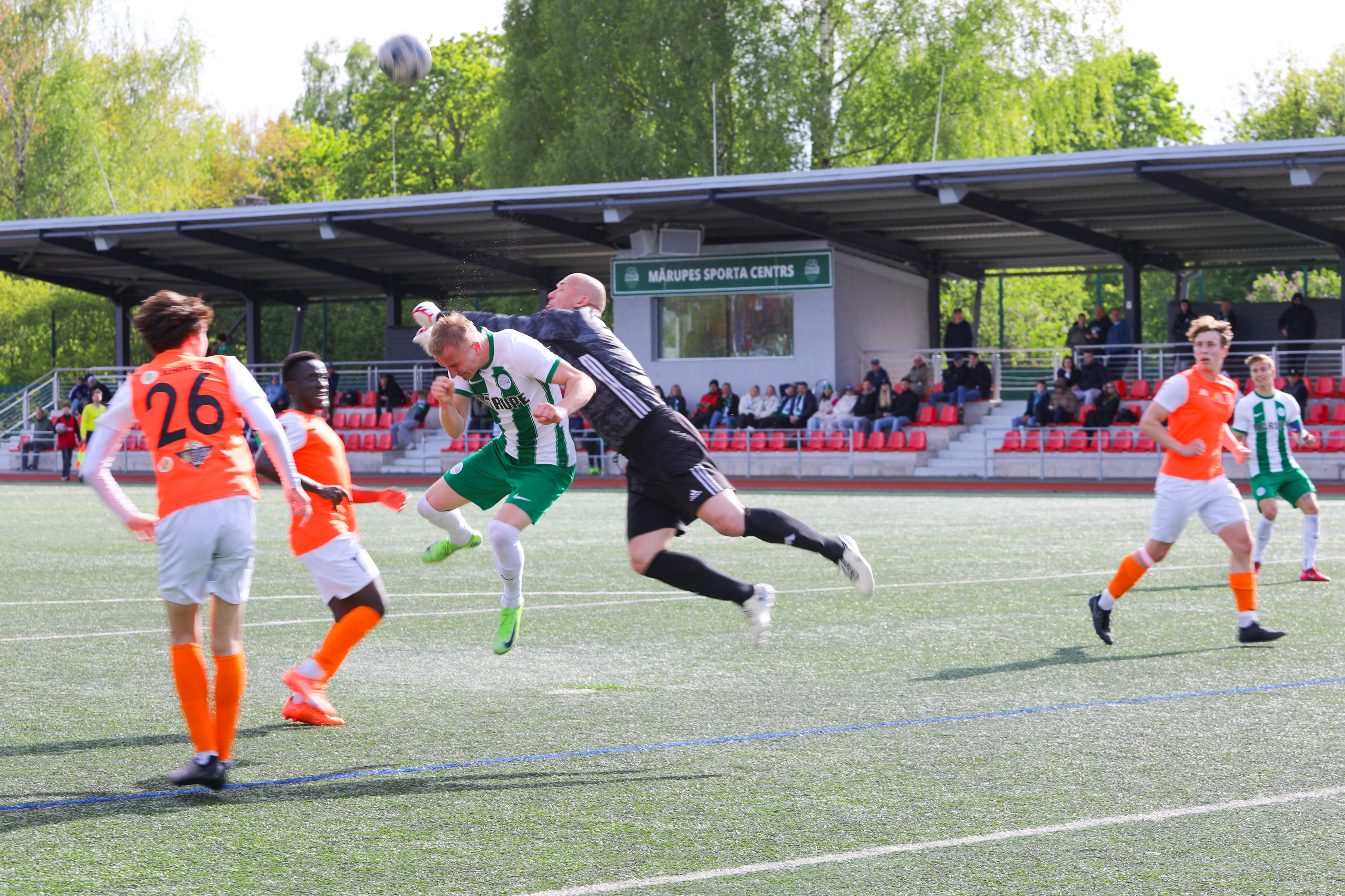 Futbola spēlētāji uz zaļa zāliena