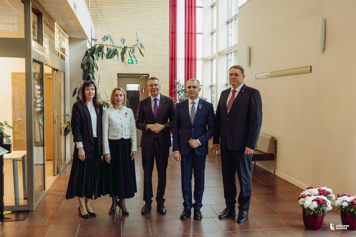 Cilvēki pozē telpā