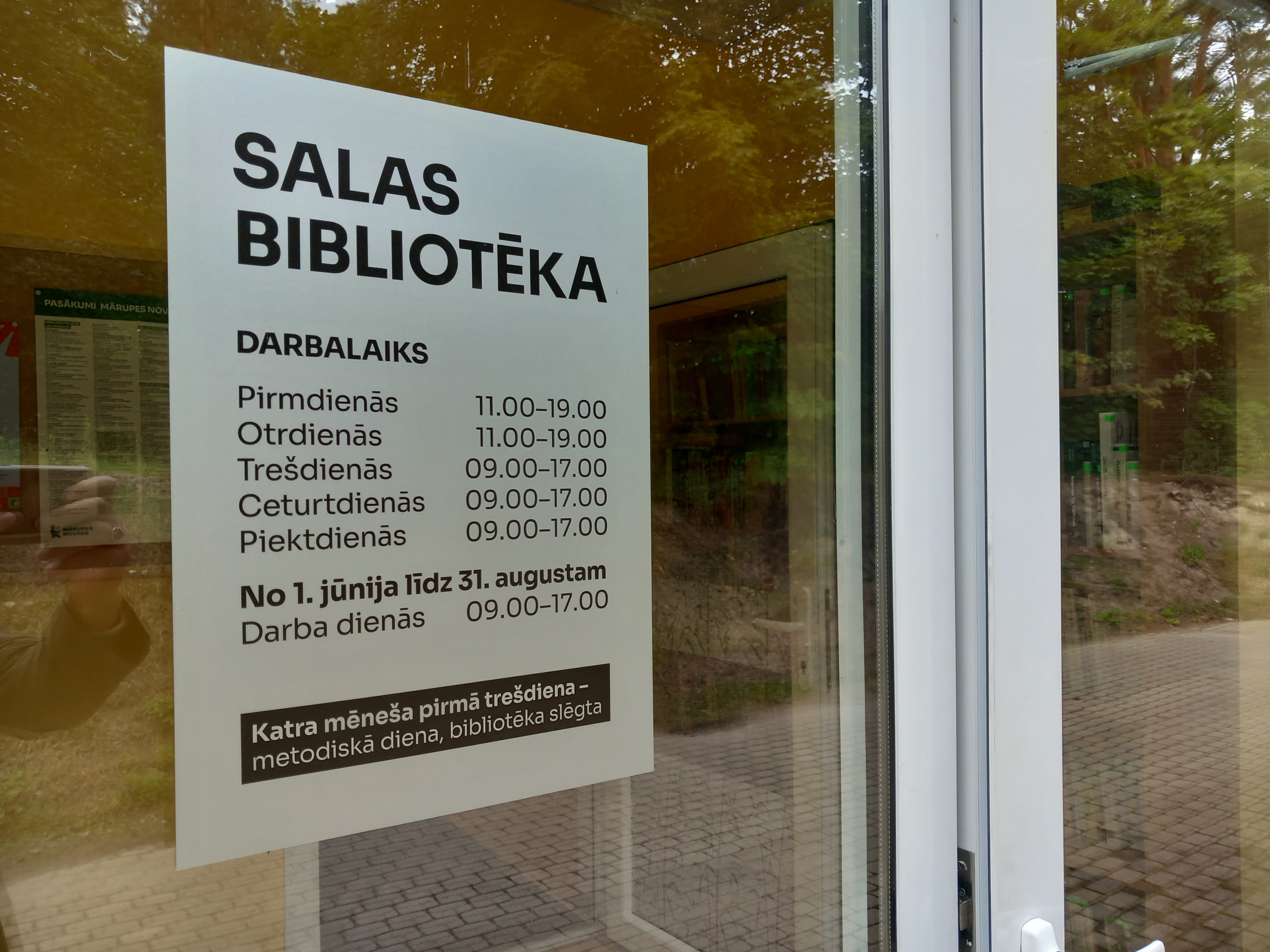 Ēkas norādes uzraksts durvju stiklā