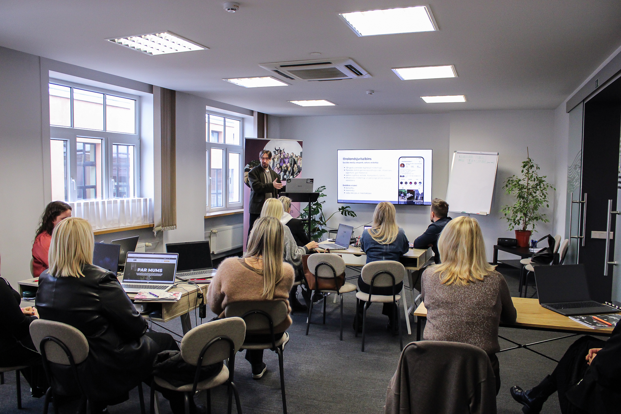 Cilvēki apmācībās gaišā telpā