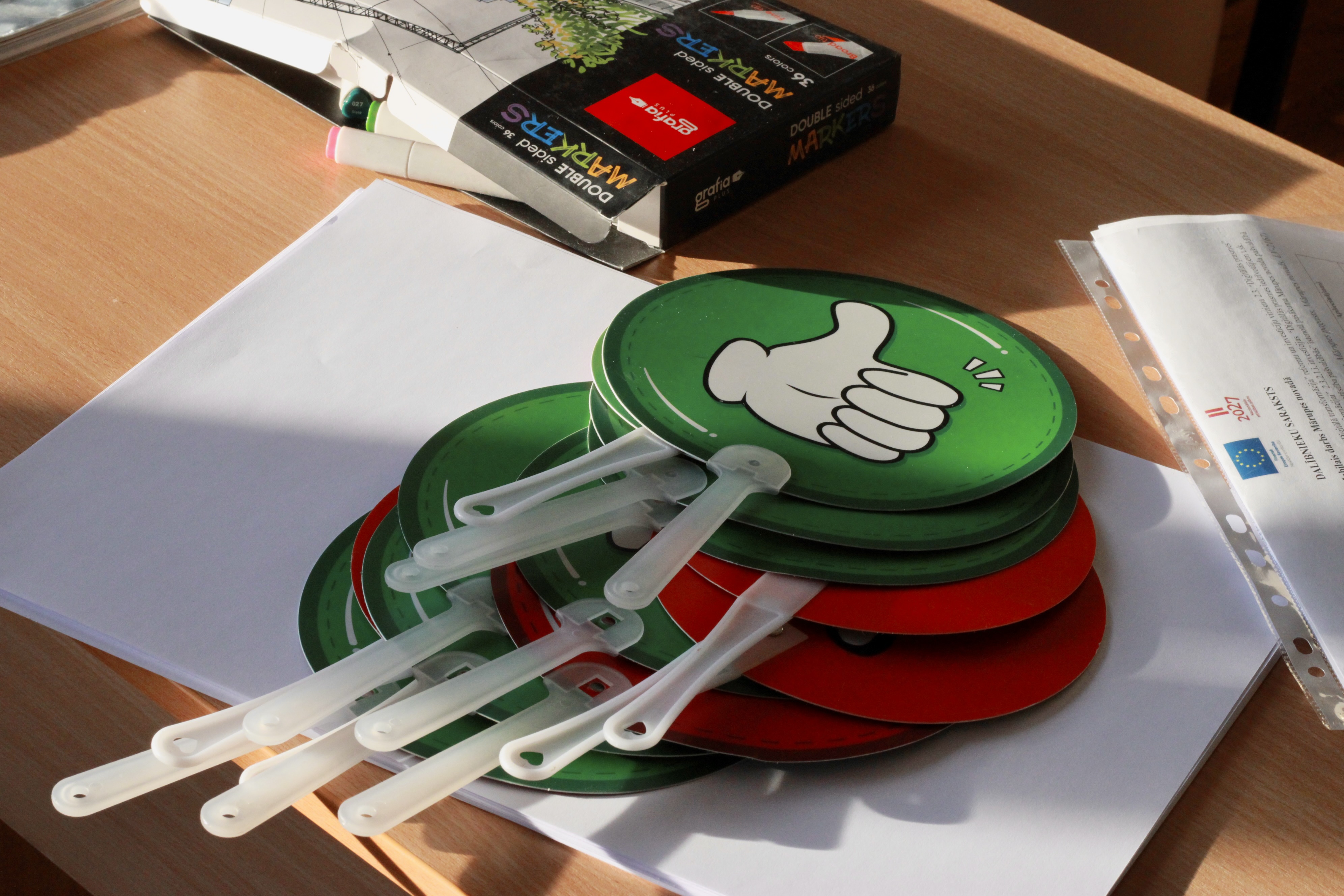 bilde ar kartiņām uz kurām attēlots īkšķis