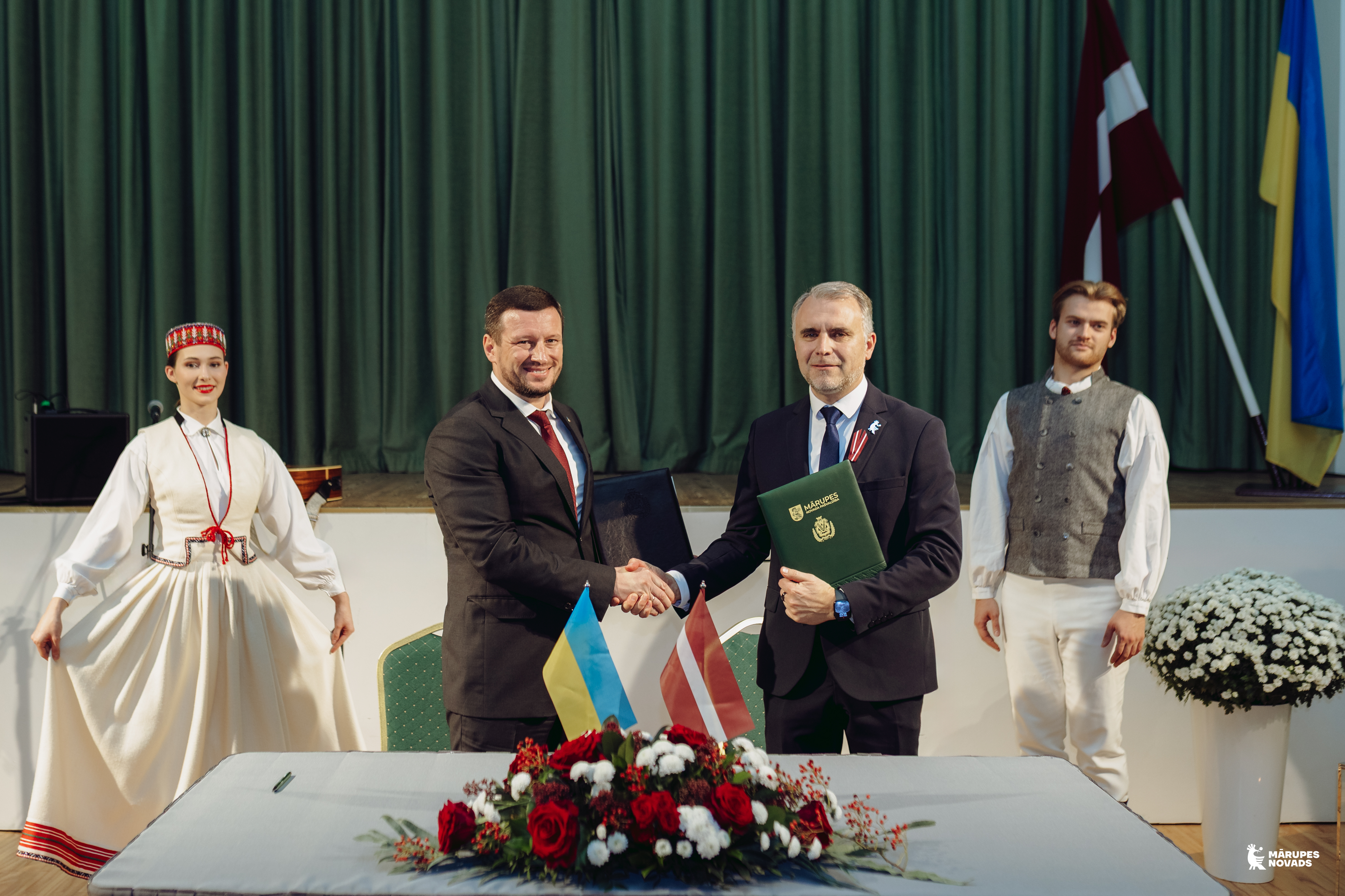 Vīrieši paspiež rokas pēc svinīga pasākuma