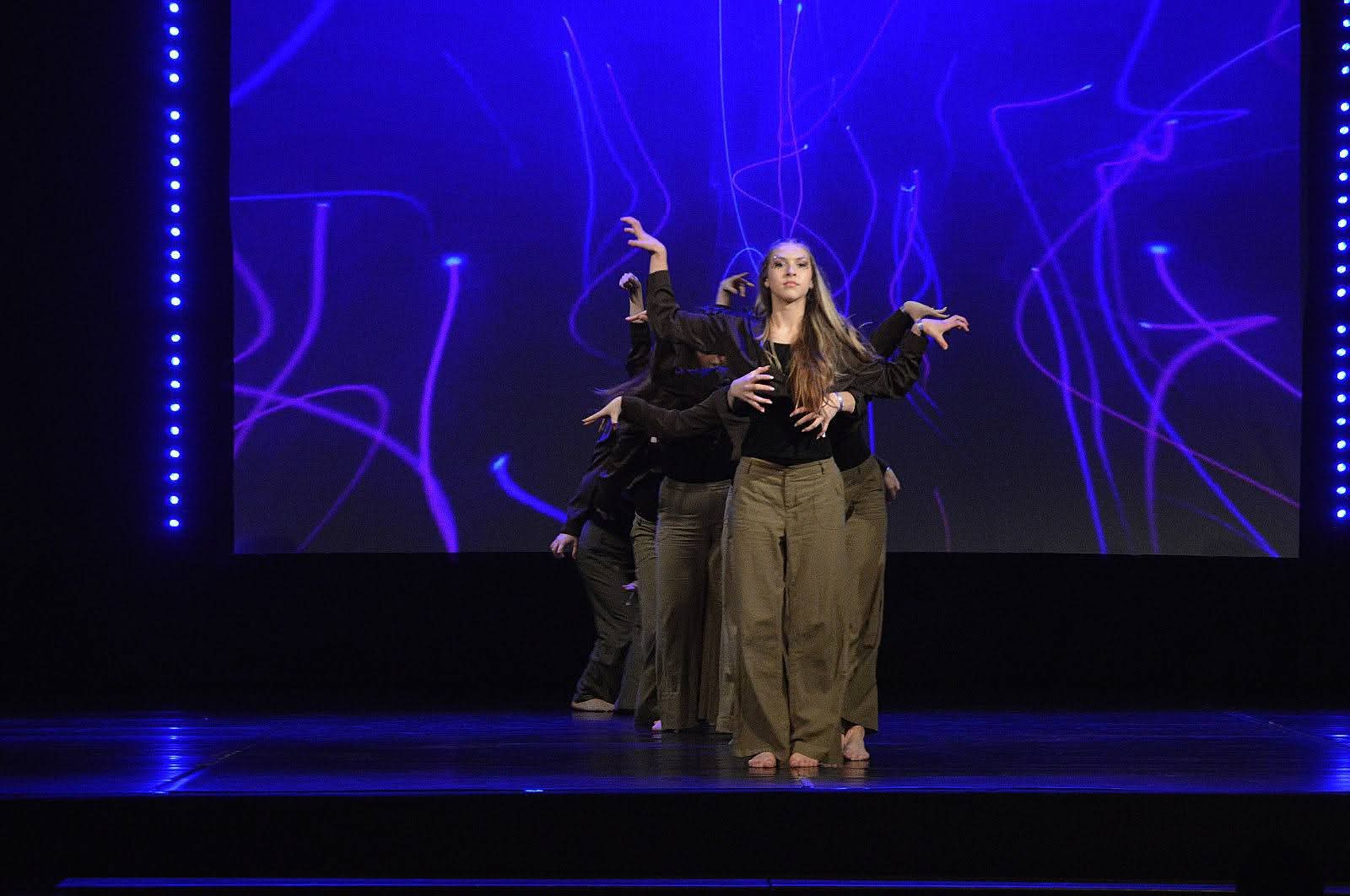 jaunieši uz skatuves, izpilda deju