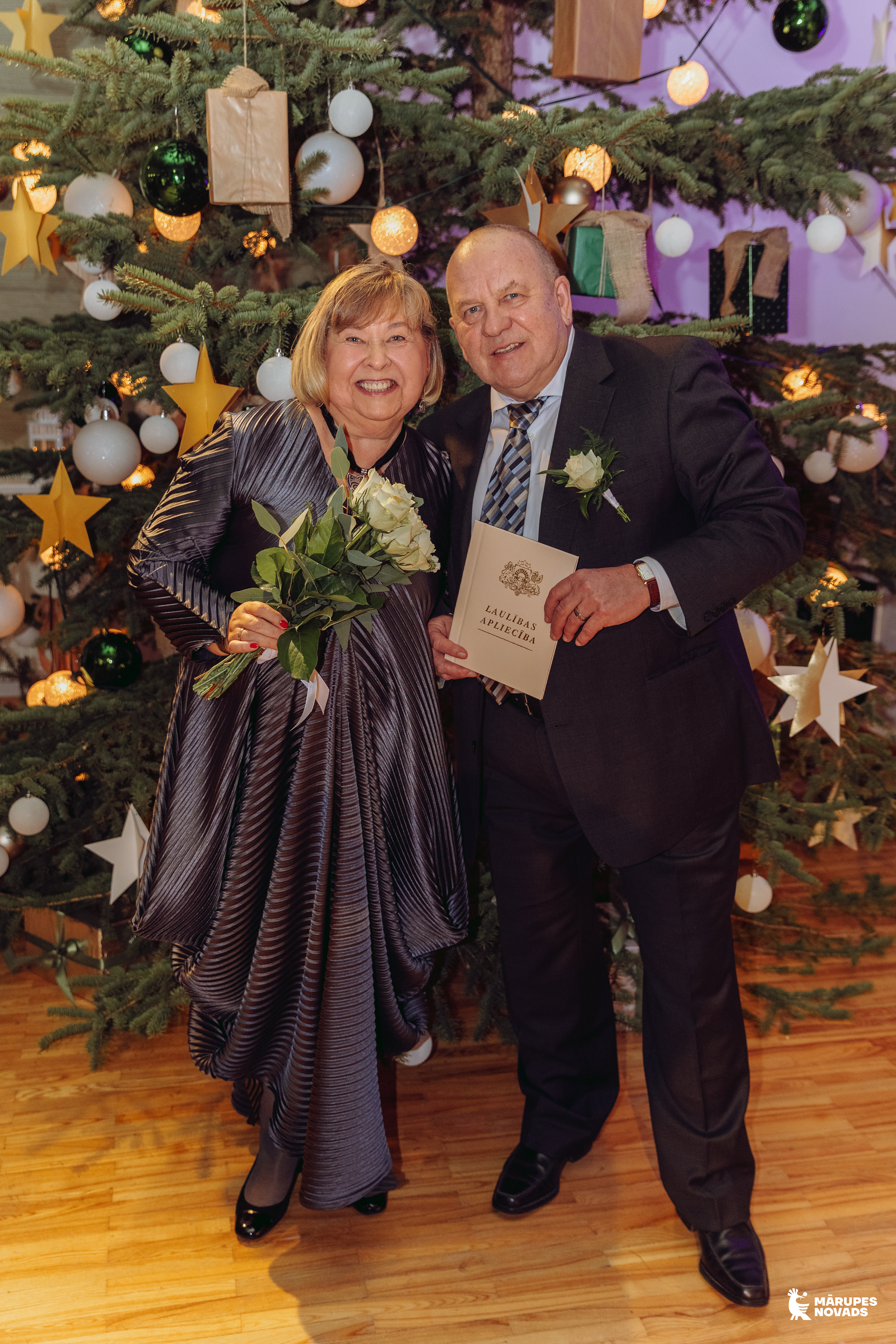 pāris pie egles telpā