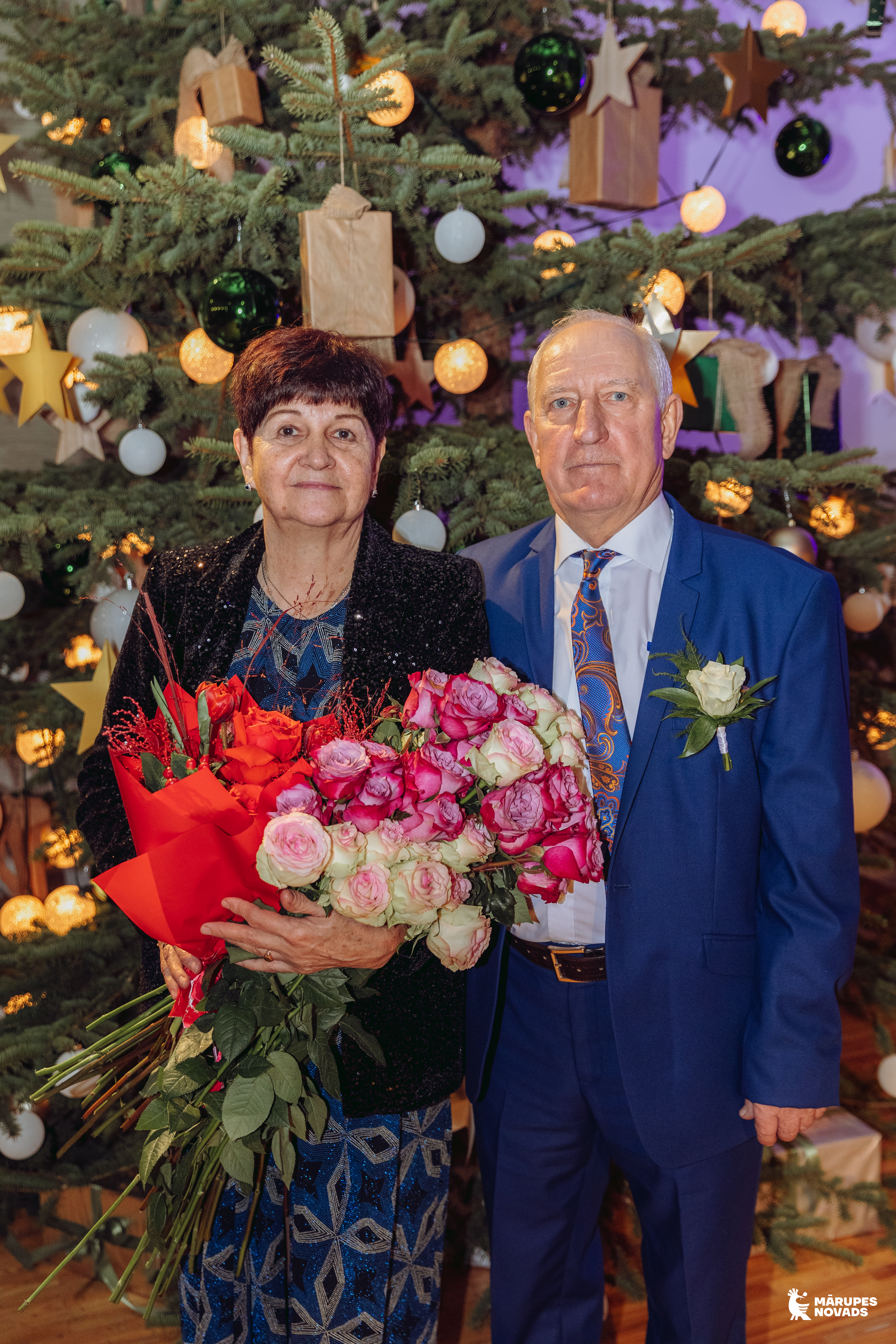 pāris pie egles telpā