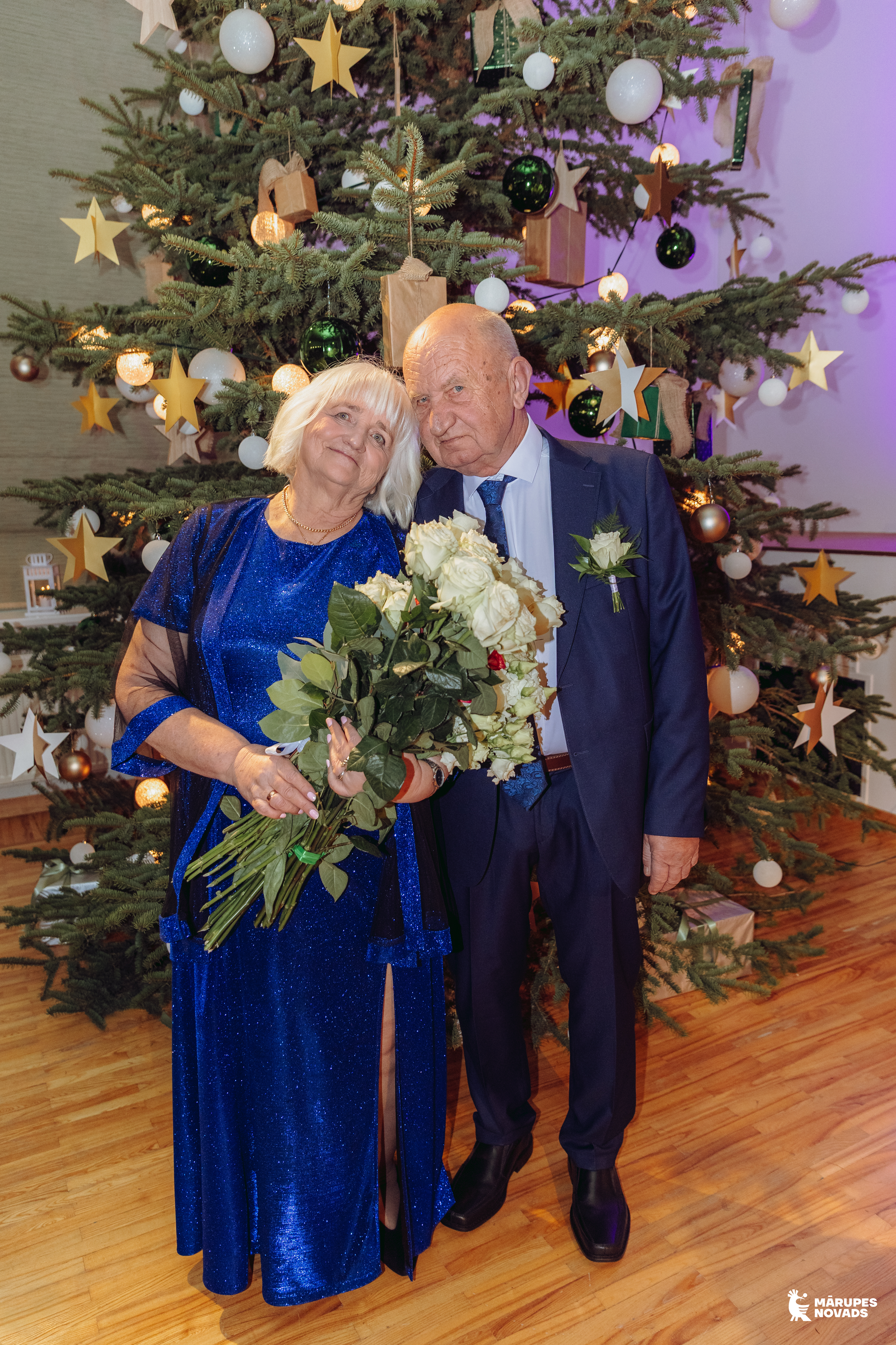 pāris pie egles telpā