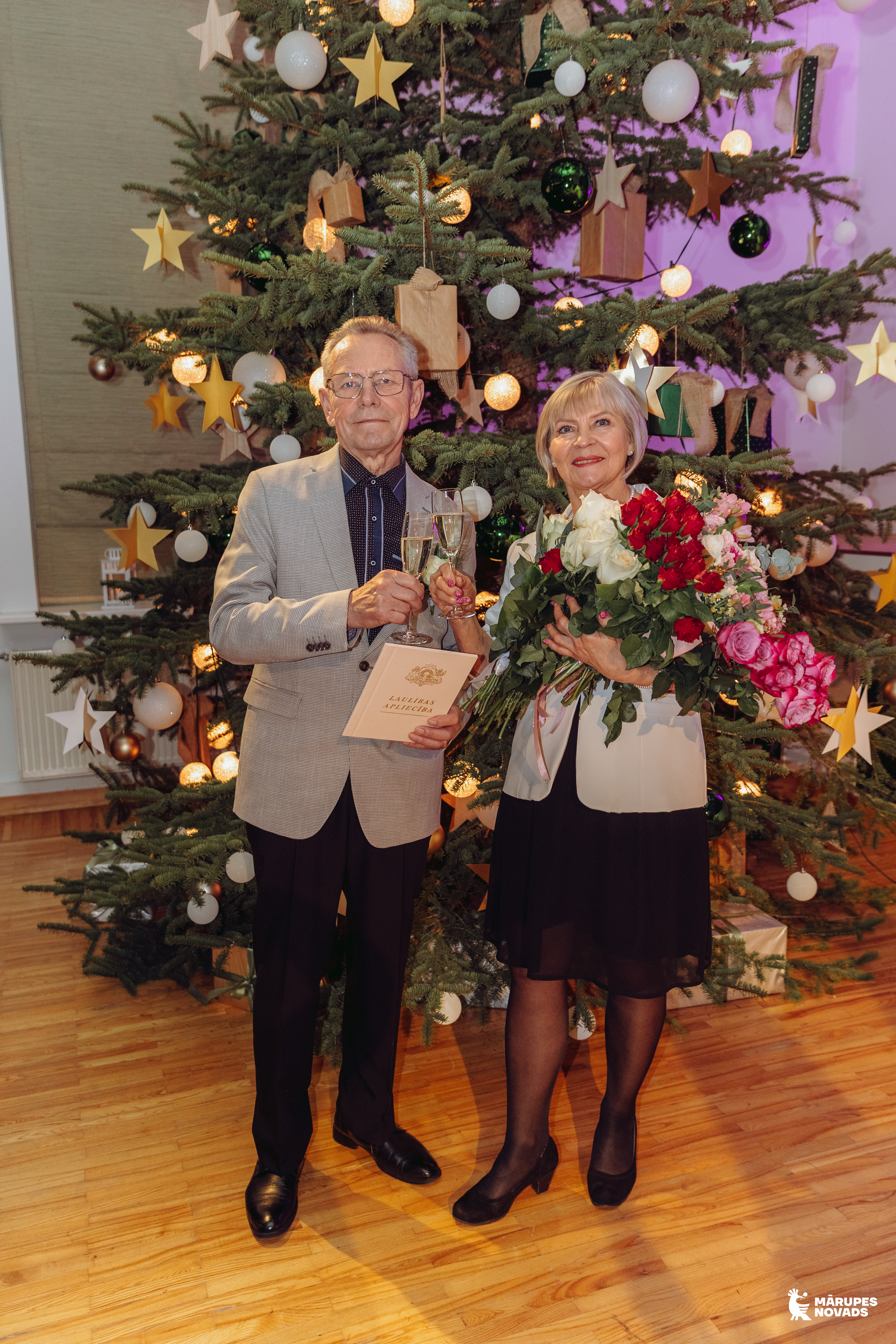 pāris pie egles telpā