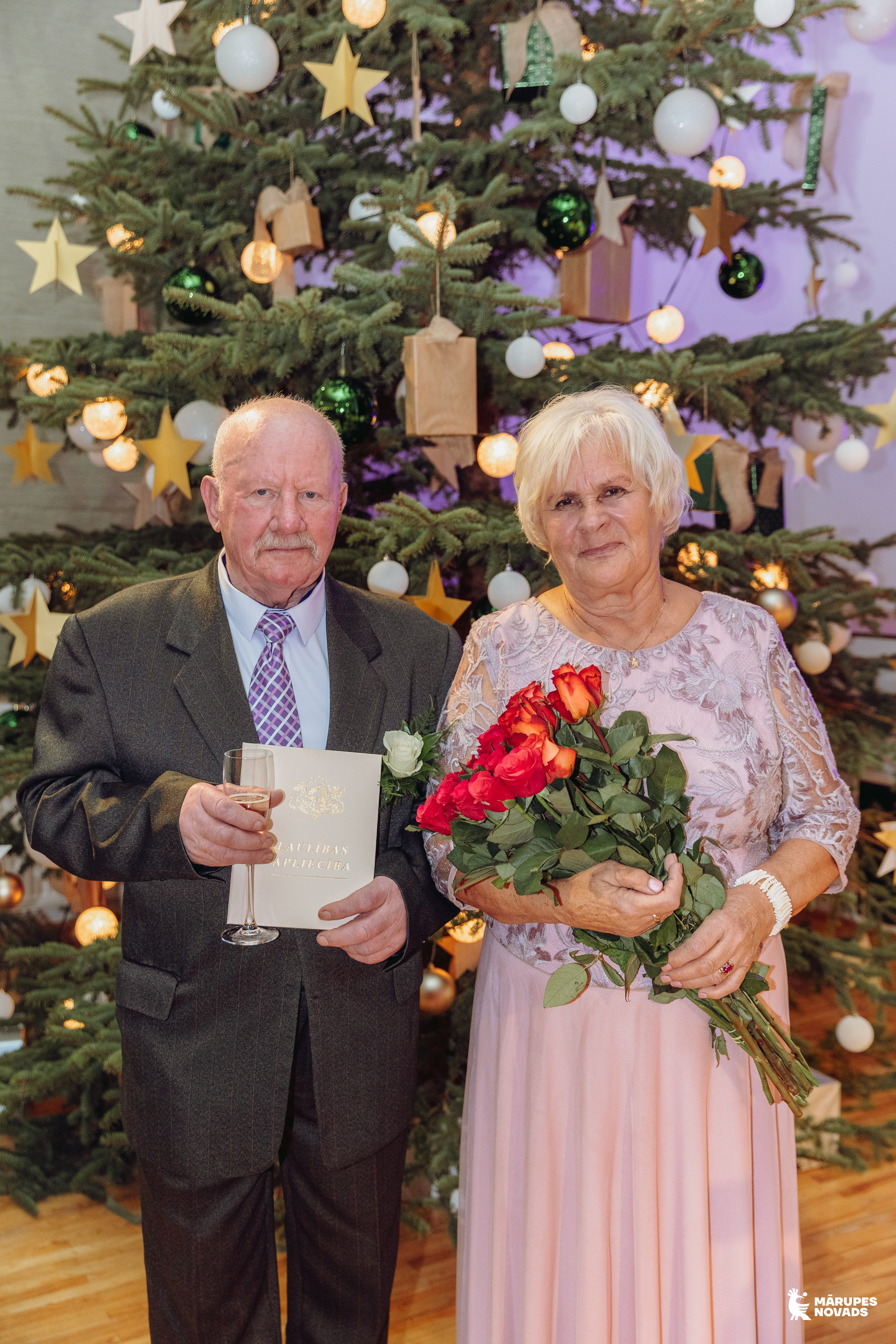 pāris pie egles telpā