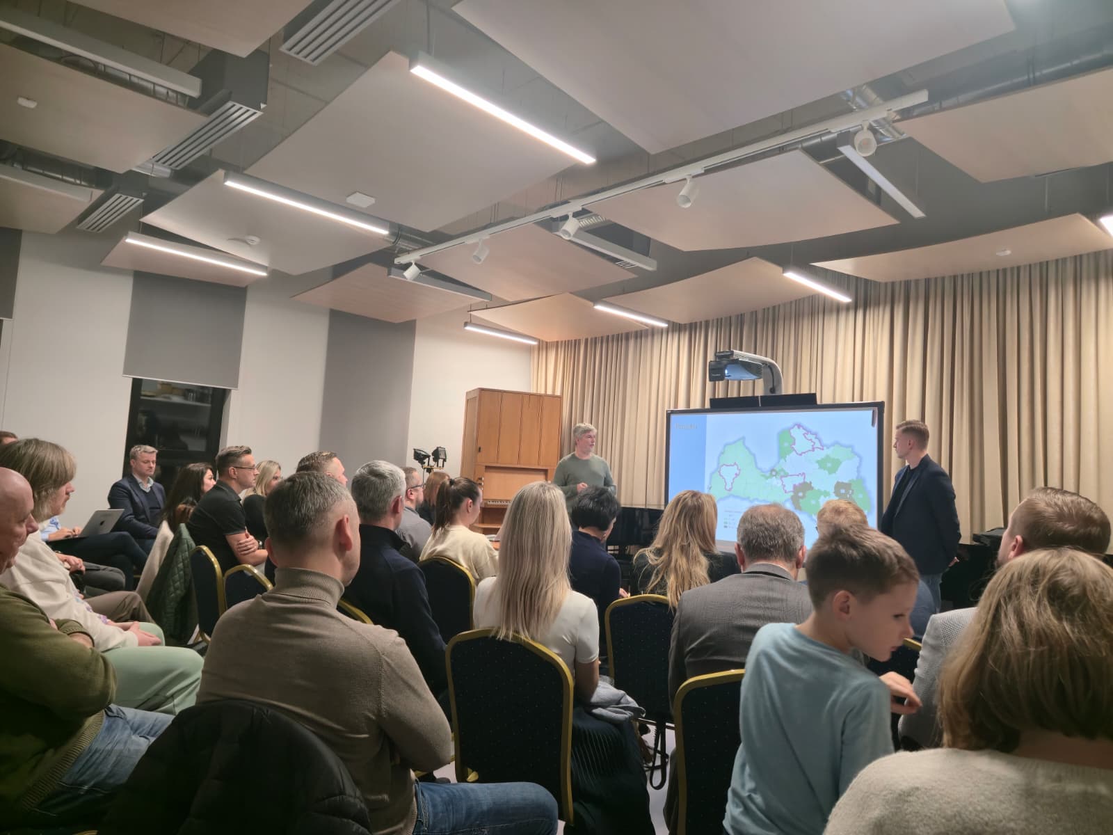 Darba grupas dalībnieki gaišā telpā