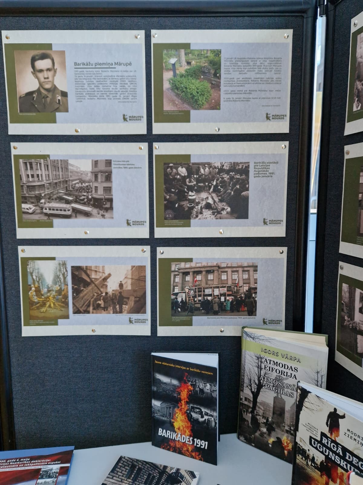 tumšs fons ar izstādes plakātiem