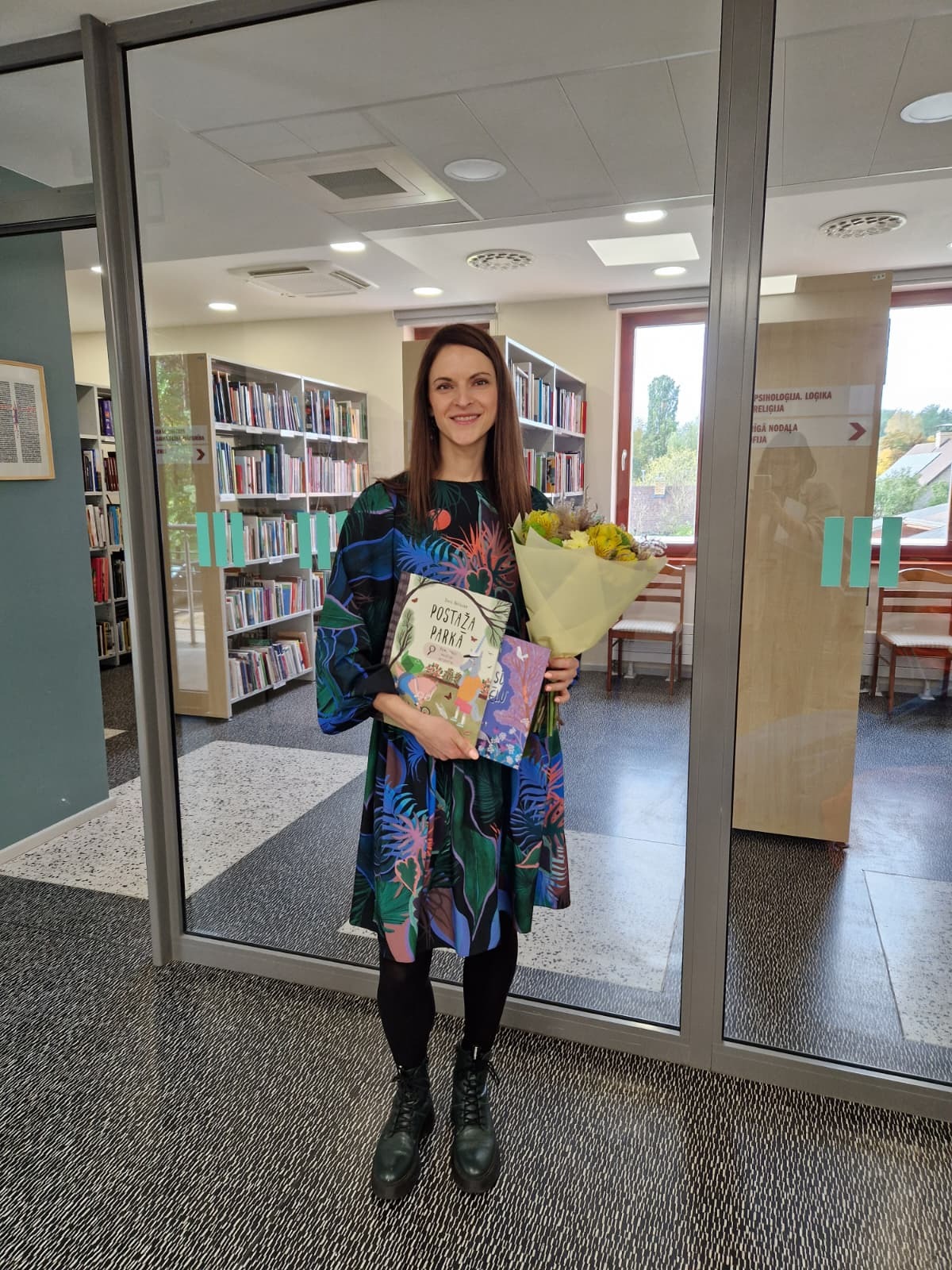 Sieviete pie stikla sienas