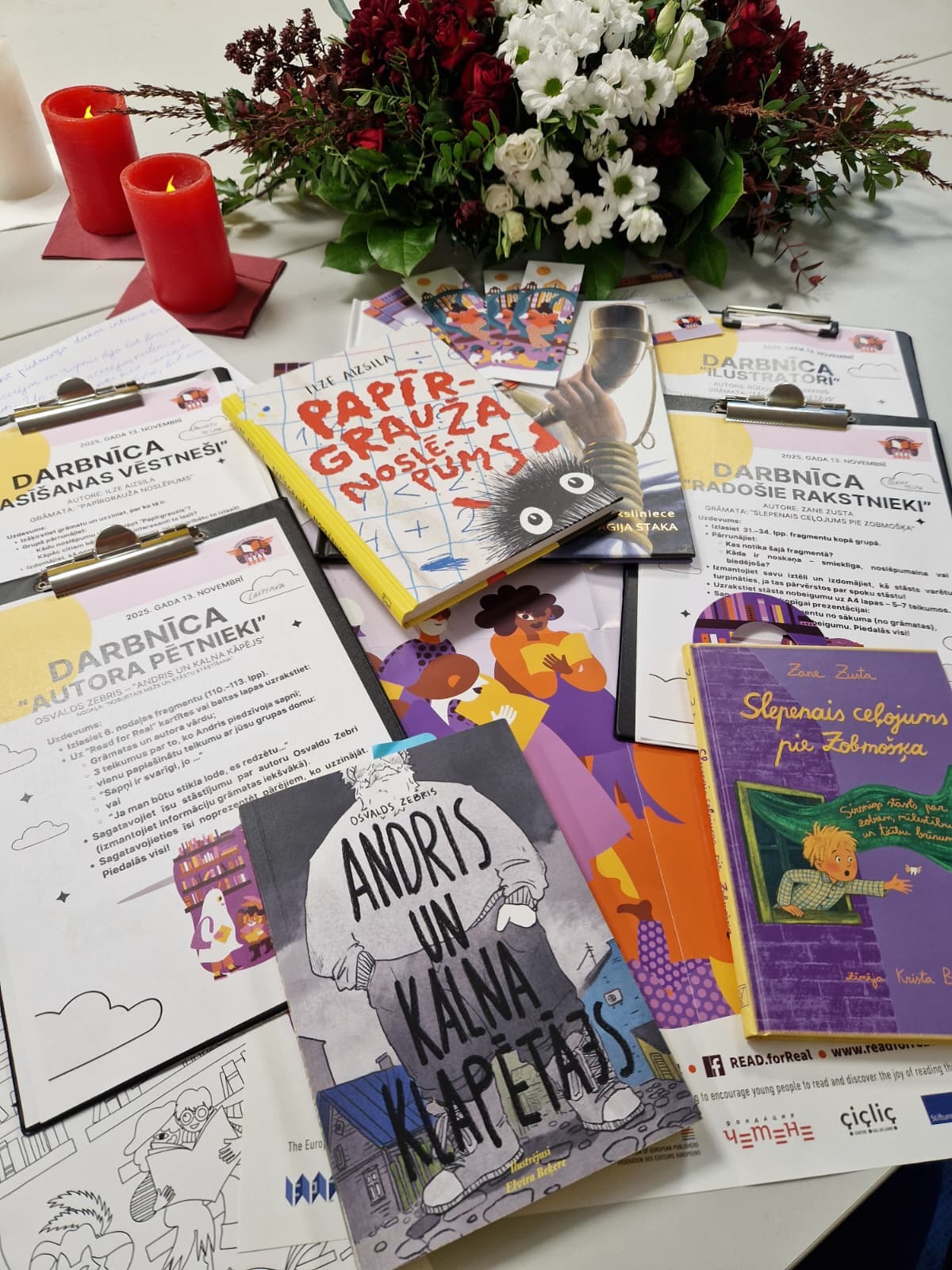 Grāmatas un zīmējumi uz galda