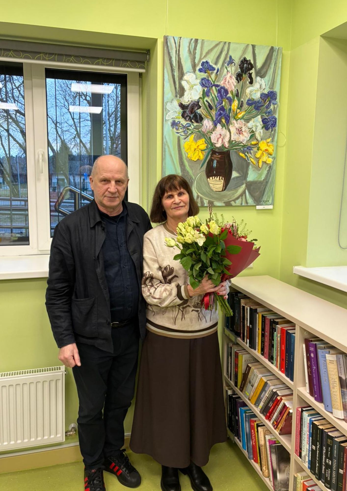 gleznotāja ar ziediem, fonā glezna