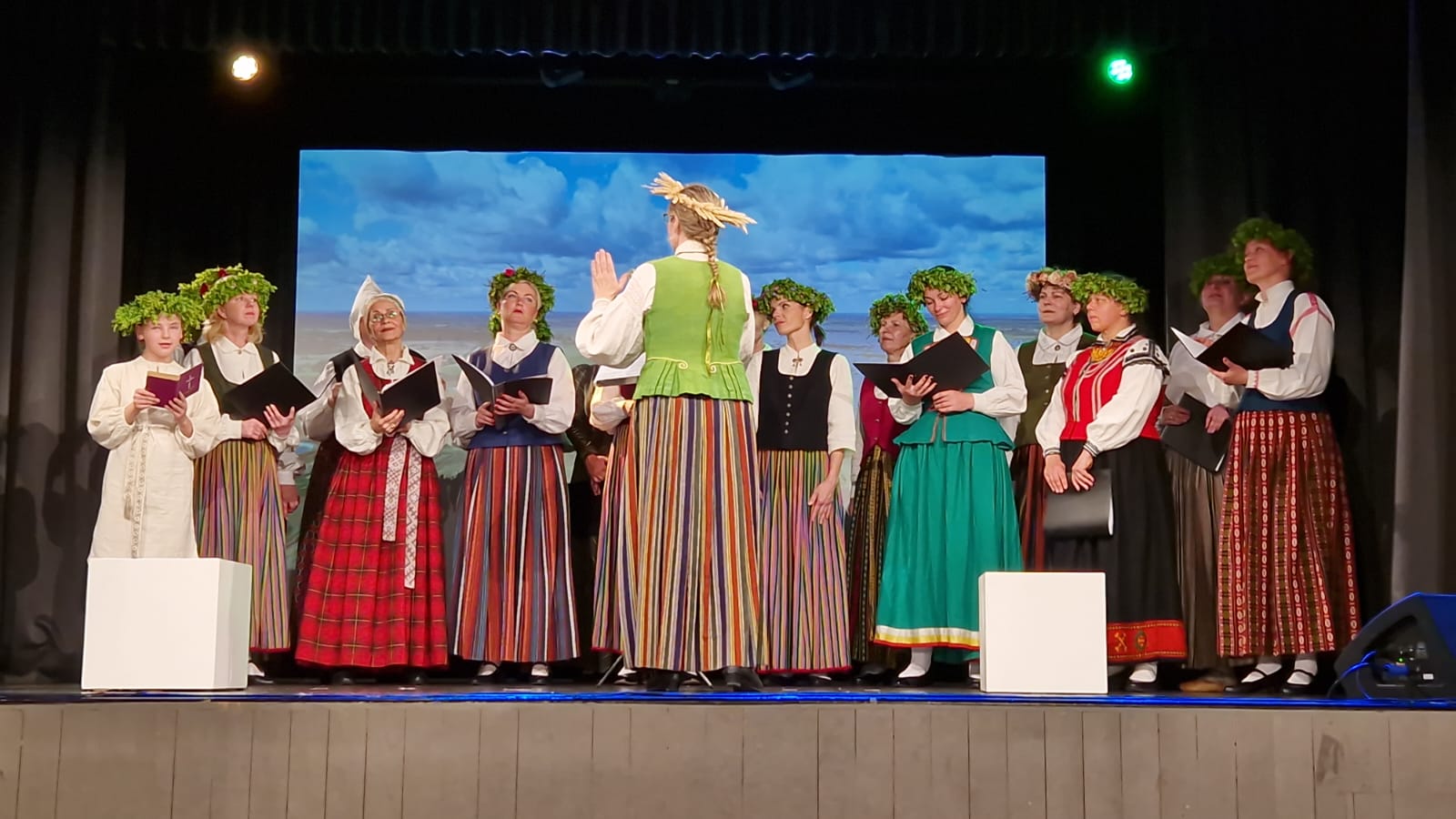 Koris tautastērpos dzied uz skatuves