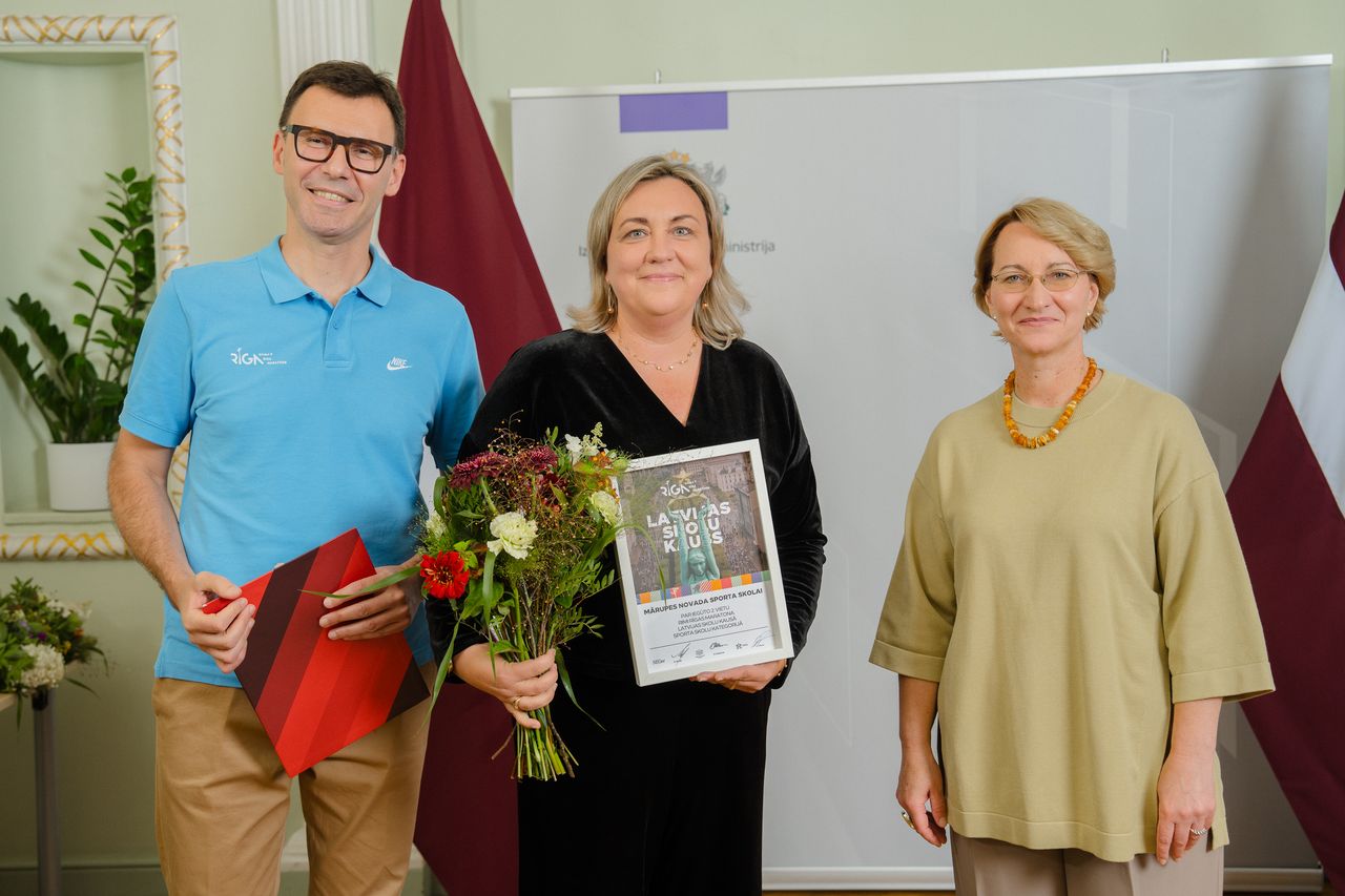 Trīs cilvēki smaida