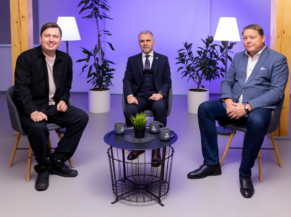 Trīs vīrieši pie melna galda