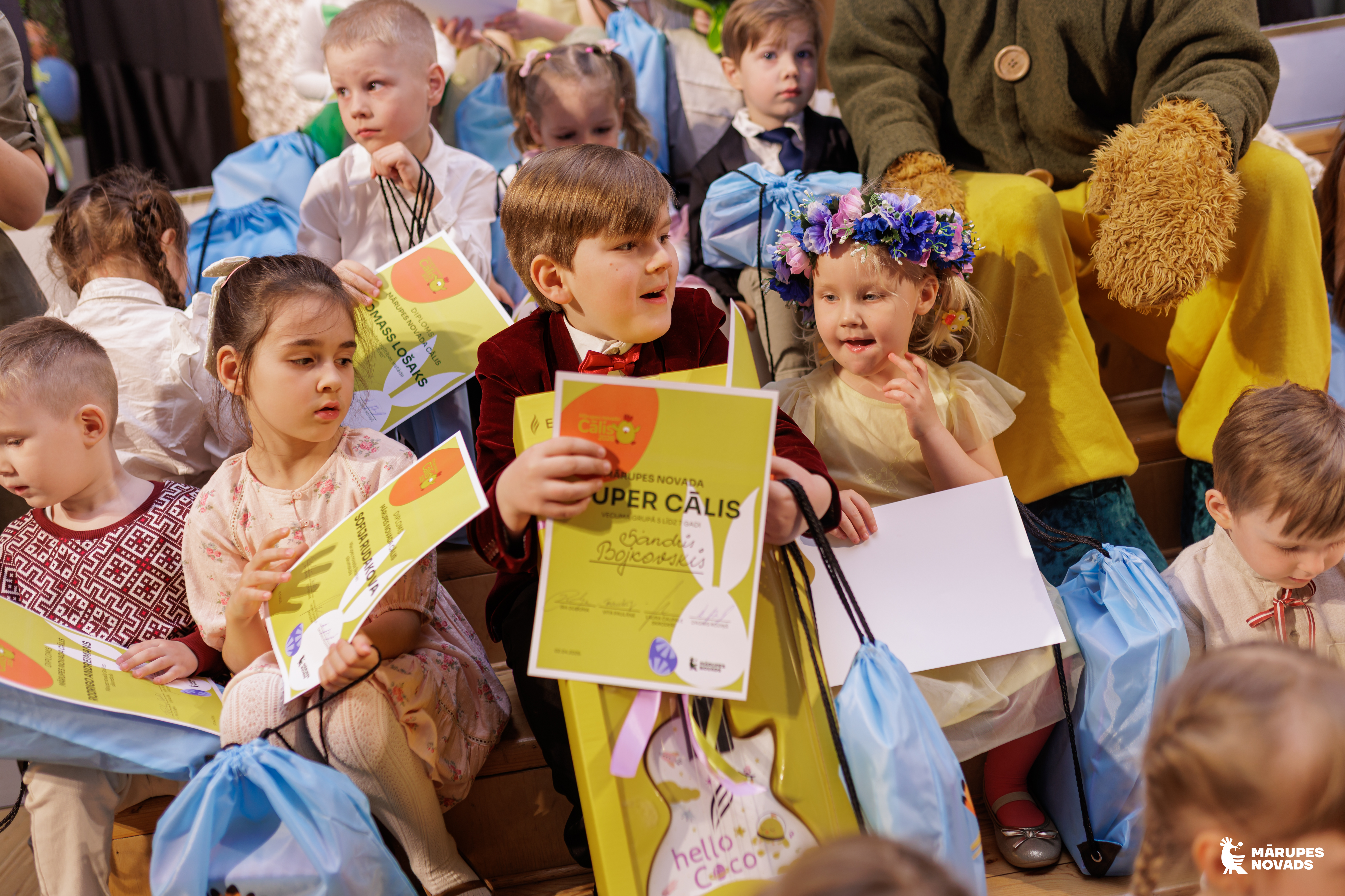 bērni, centrā viens ar diplomu un balvām