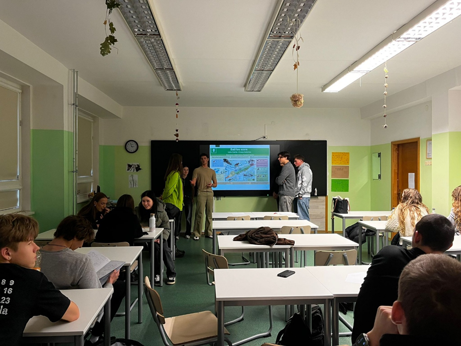 Klases telpa ar skolēniem un galdiem