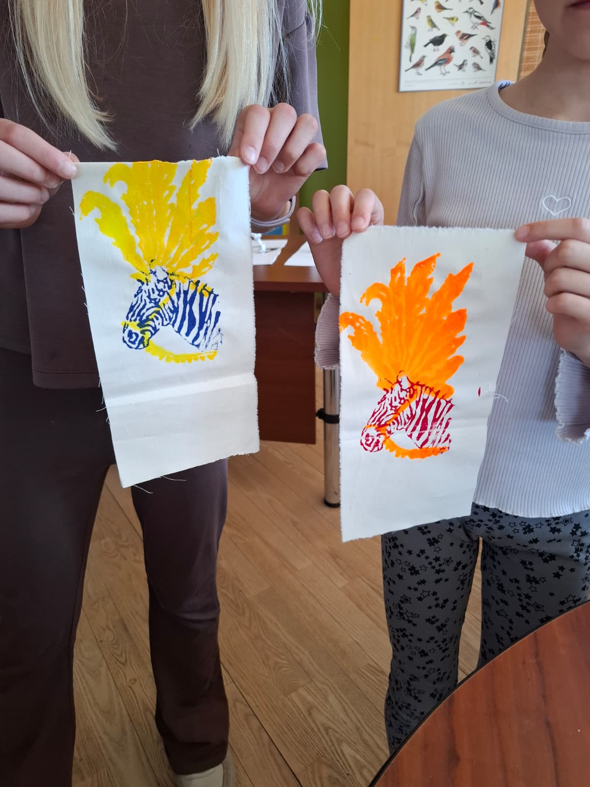 bērni tur rokās sietspiedes darbus ar zebru