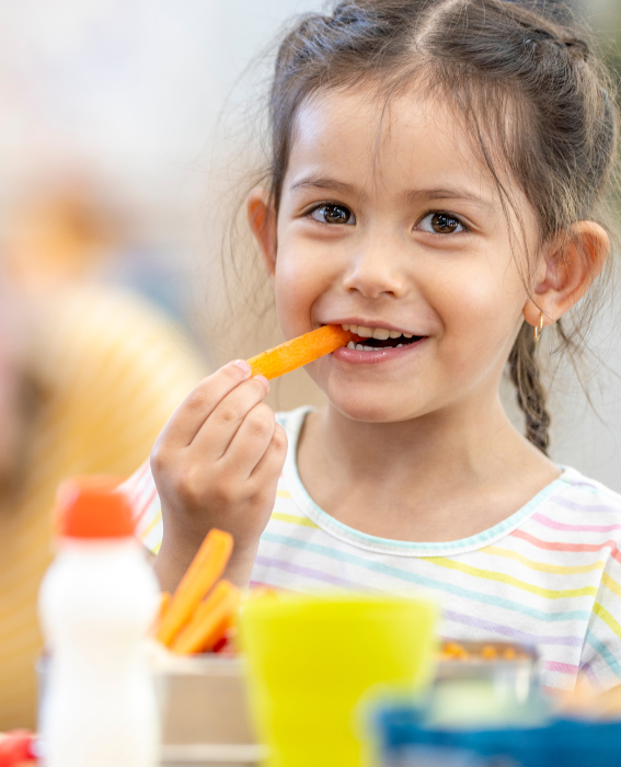 Meitene smaida un ēd burkānu