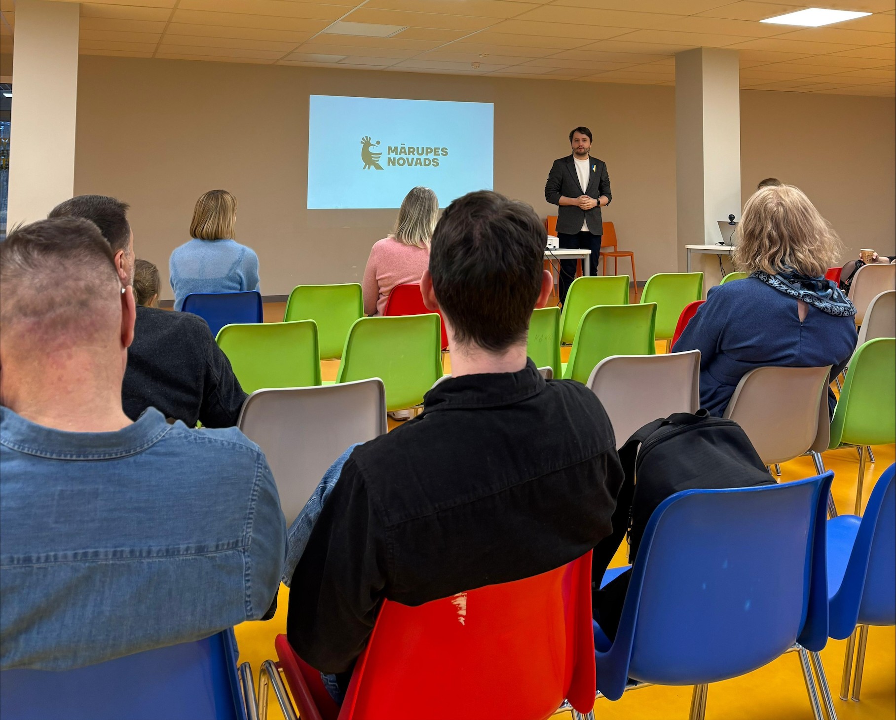 Cilvēks stāv, pārējie sēž