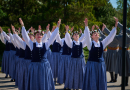 Sievietes tautas tērpos dejojot āra laukumā