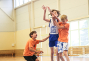 Puiši spēlē basketbola sporta zālē