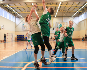 Puiši spēlē basketbola sporta zālē
