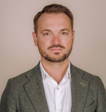 Vīrieša profils gaišā uzvalkā uz gaiša fona