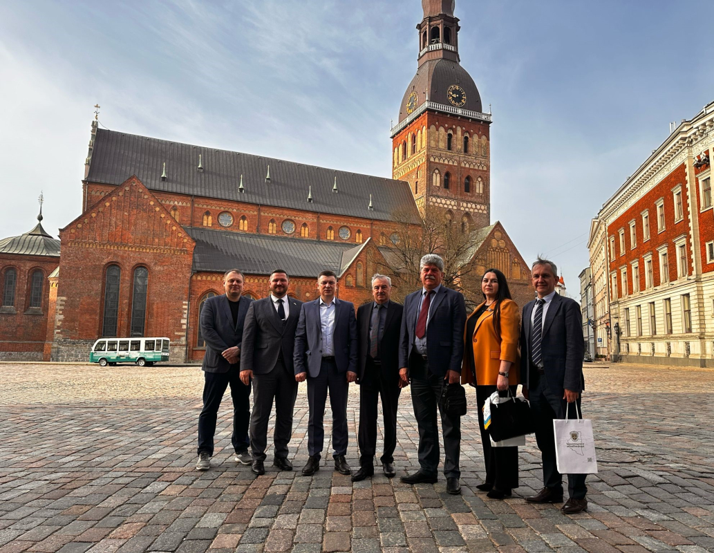 Delegācijas pārstāvji Rīgas vecpilsētas laukumā uz Doma baznīcas fona