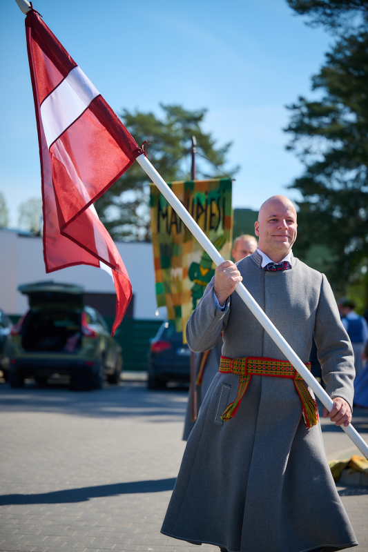 Tautu dēls ar Latvijas karogu rokās
