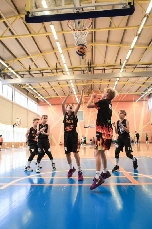 Puiši spēlē basketbola sporta zālē
