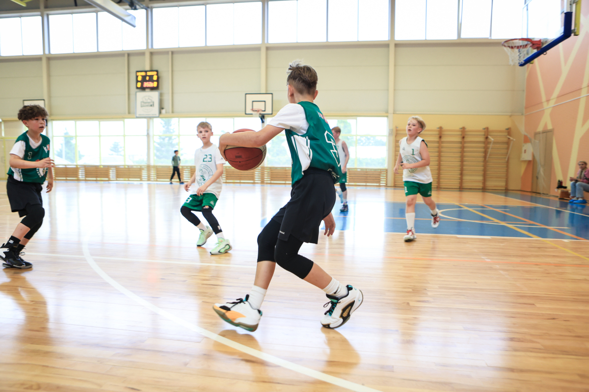 Puiši spēlē basketbola sporta zālē